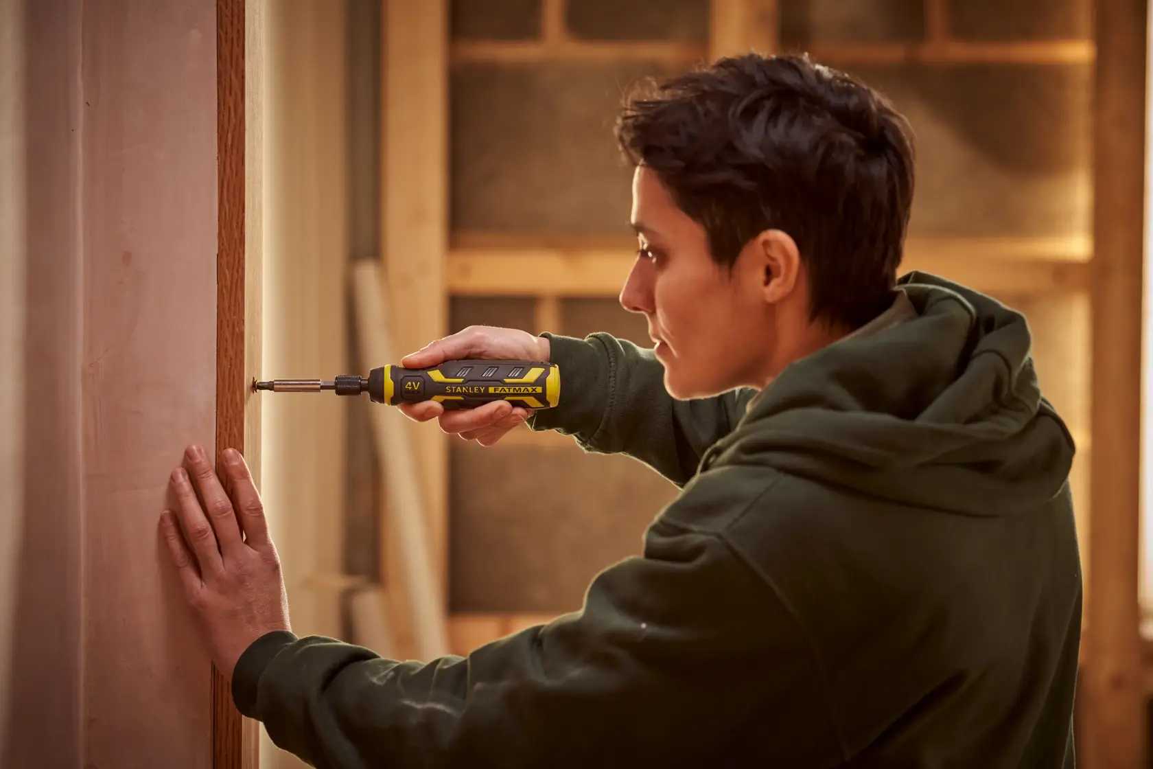Stanley FMHT66719-0 electric screwdriver used by a person in a workshop setting.