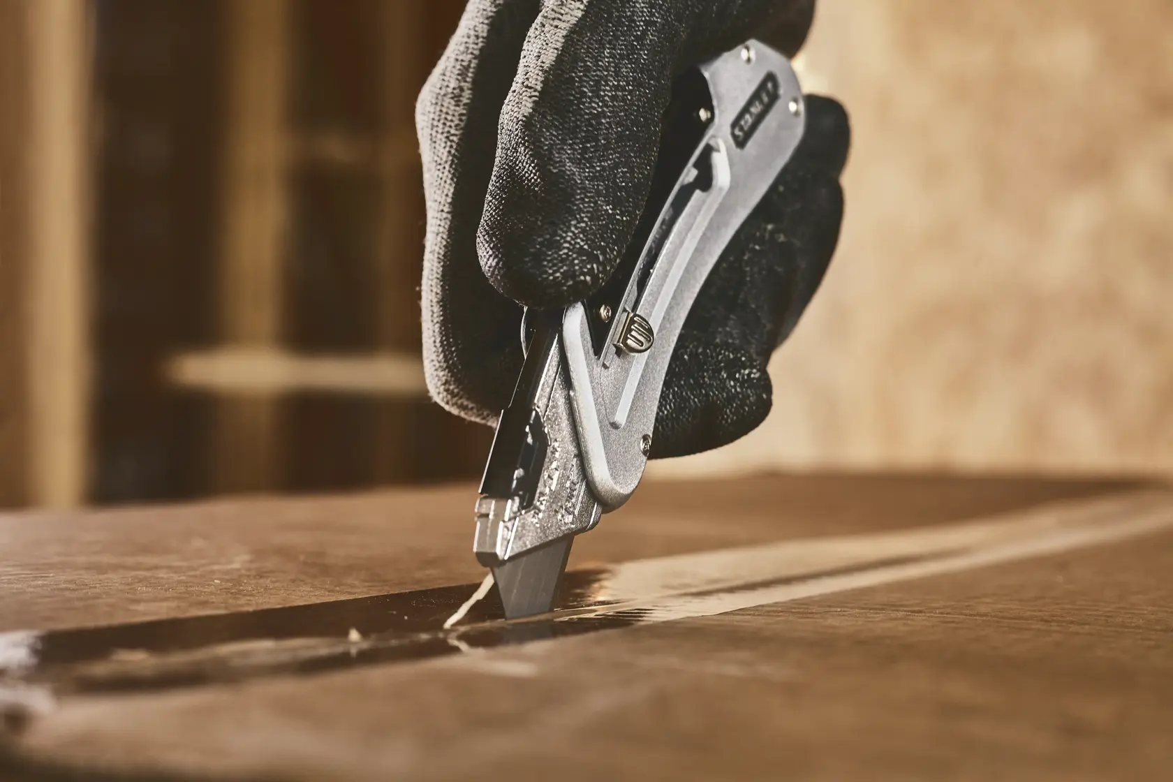 Foto vom STANLEY 0-10-810 Universalmesser mit silbernem Gehäuse, in Hand gehalten, Seitenansicht auf weißem Hintergrund.