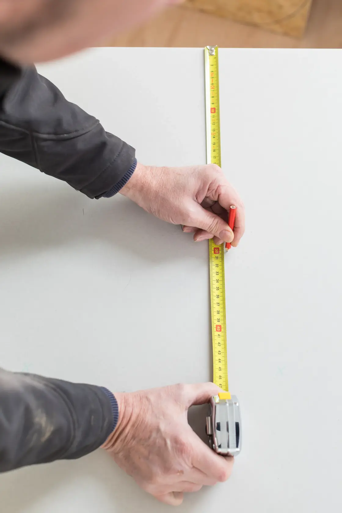 Photo of STANLEY 0-33-194 tape measure being used to measure and mark on a white surface.