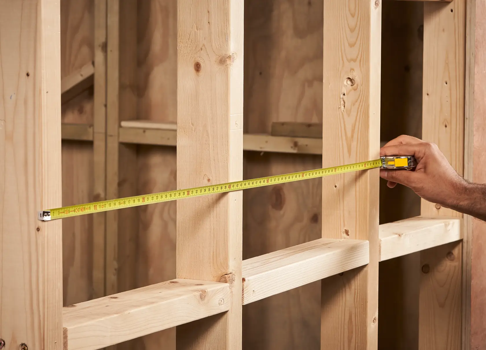 STANLEY 0-33-218 tape measure stretched across wooden framing, photo of product in use.