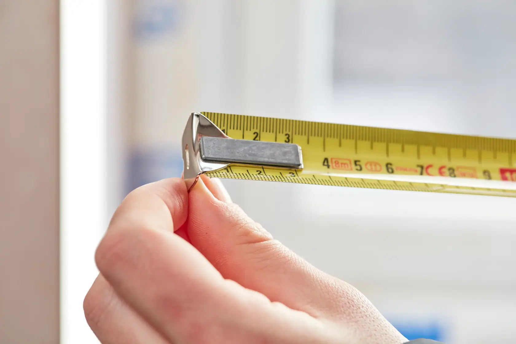 STANLEY 0-33-527 yellow tape measure held in hand, close-up photography showing measurement markings.