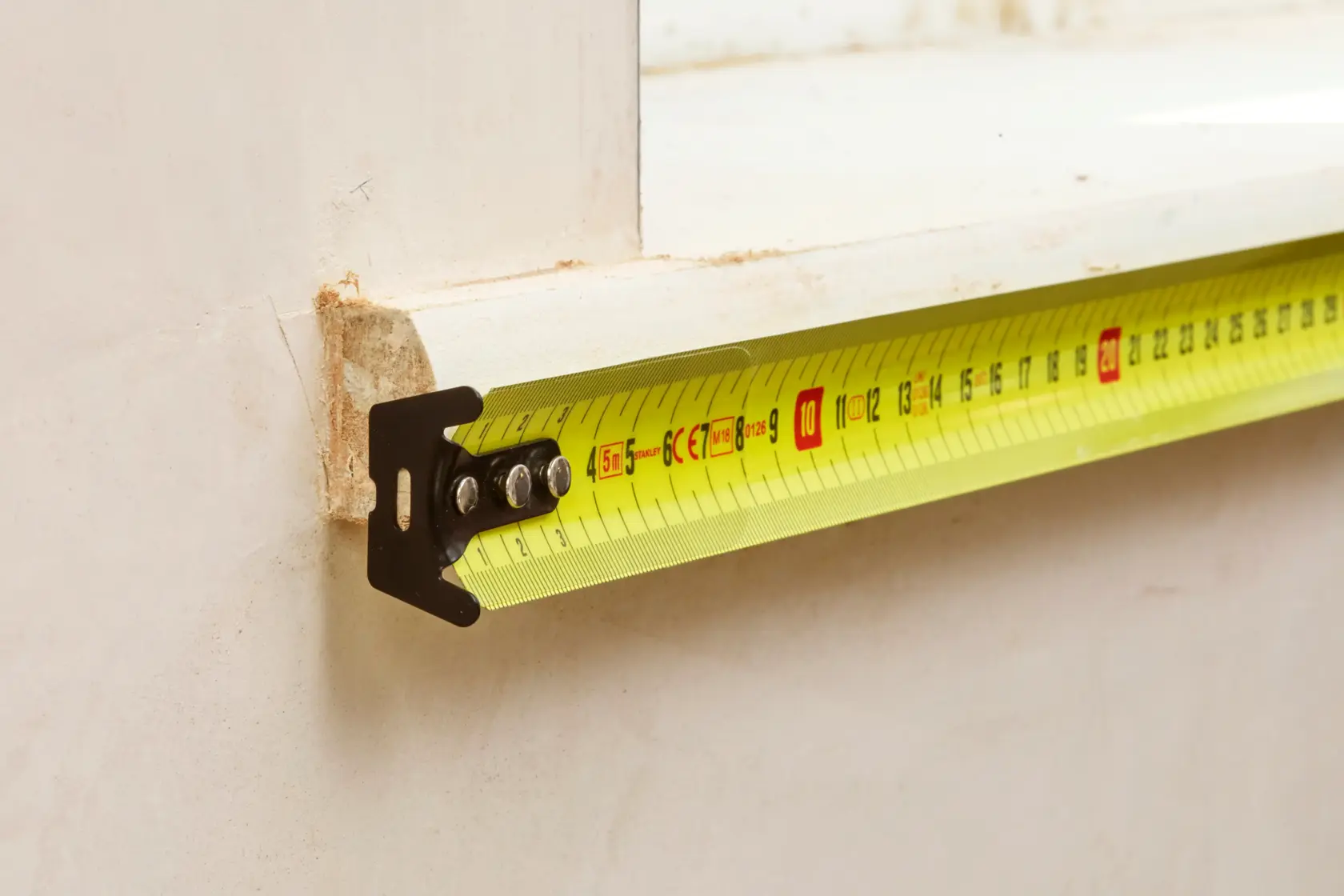 STANLEY 0-33-720 tape measure photography, yellow blade extended on a white background, side angle.