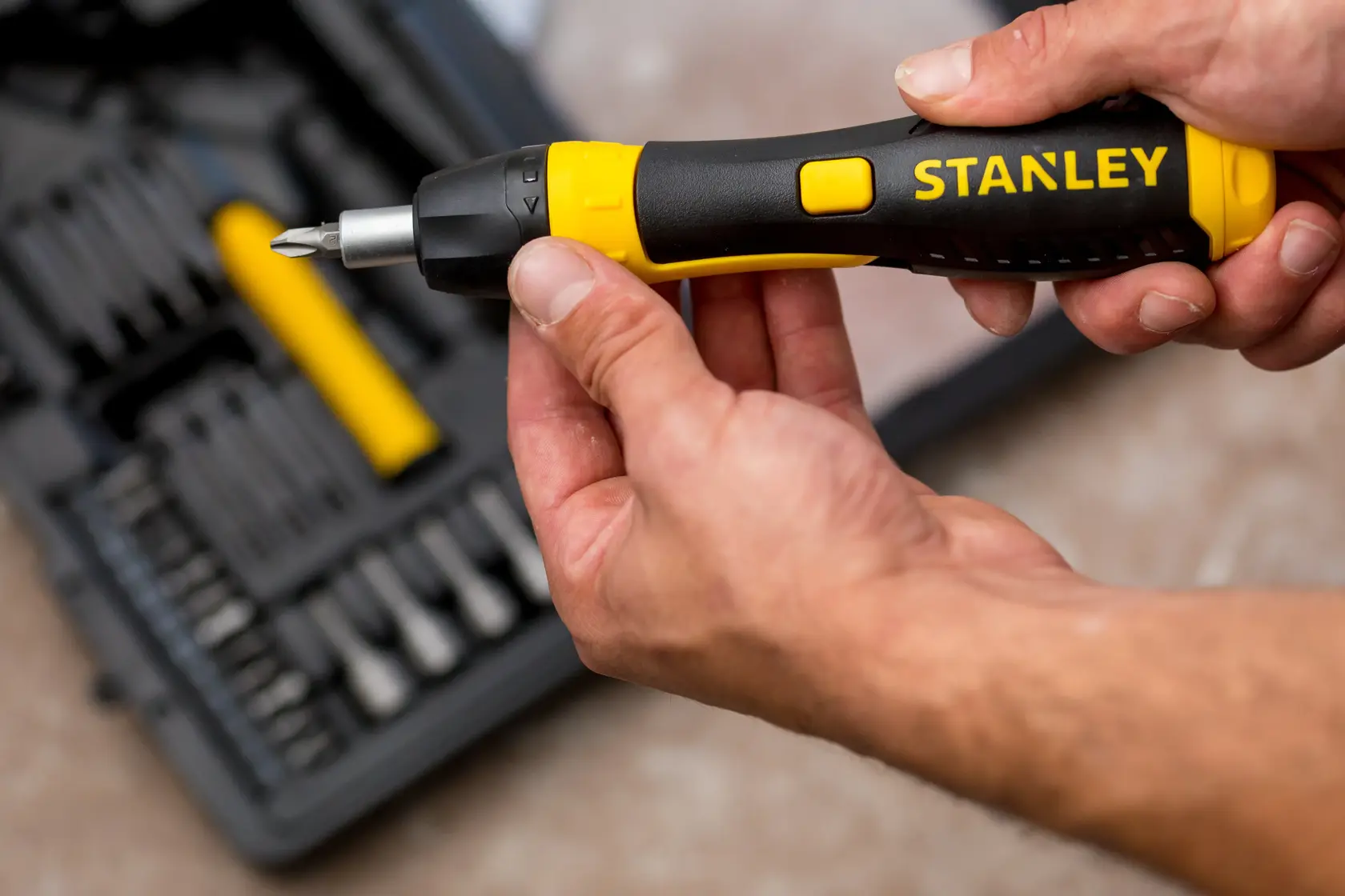 Photo of STANLEY 0-63-038 ratcheting screwdriver with black and yellow handle, tool kit background.