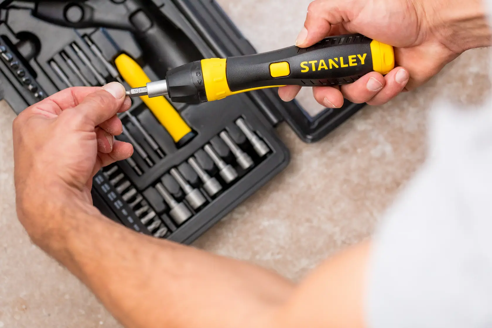 STANLEY 0-63-038 ratcheting screwdriver set shown in use with bits and black storage case on tabletop.