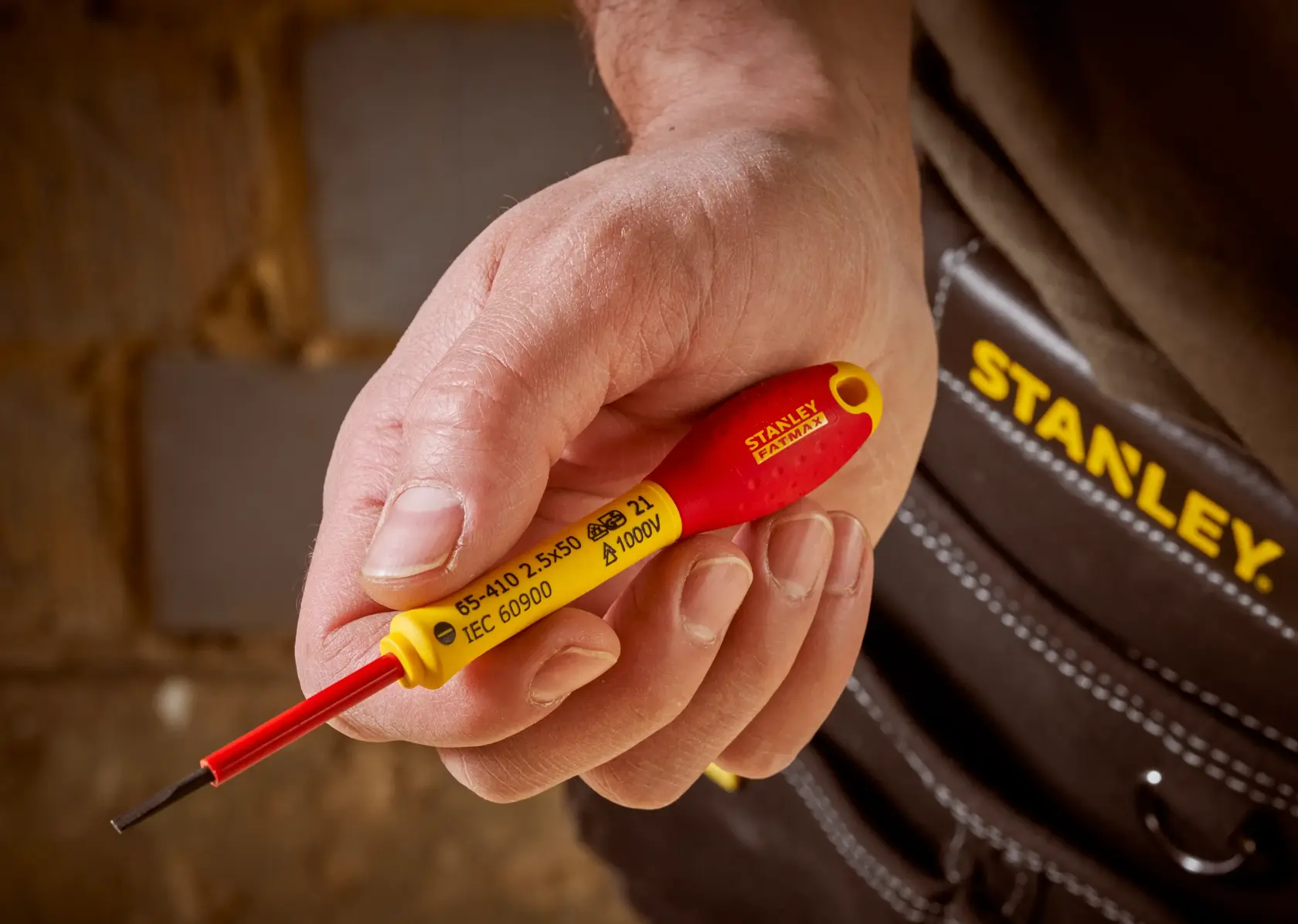 STANLEY 0-65-410 insulated screwdriver held in hand, red and yellow handle, close-up photography.