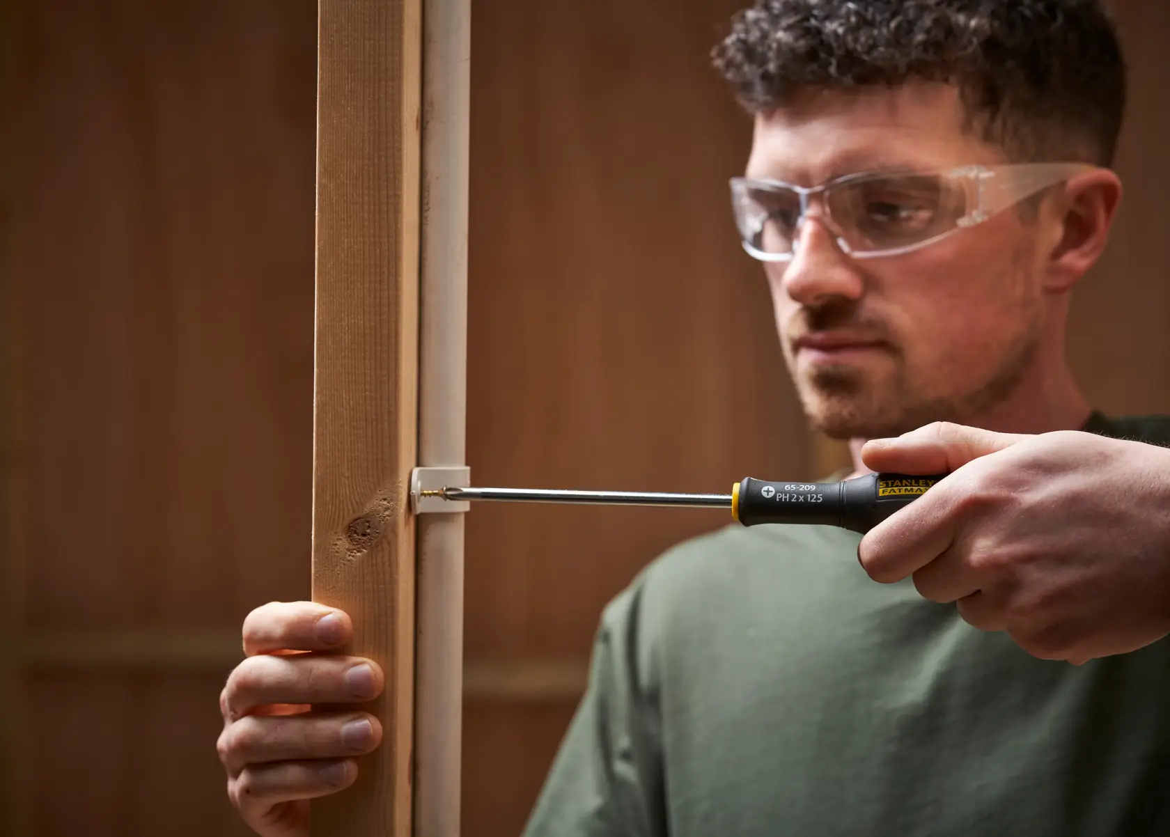 Photo of STANLEY 0-65-437 screwdriver used to fasten screw into wood frame.