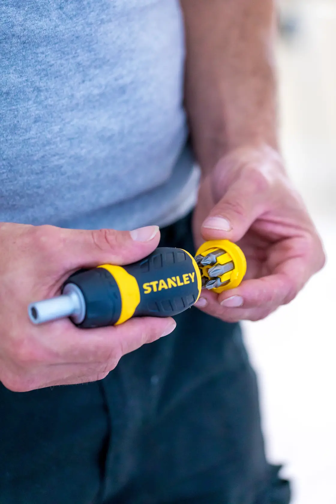 Photo of STANLEY 0-66-358 screwdriver with yellow and black handle showing bit storage in use.