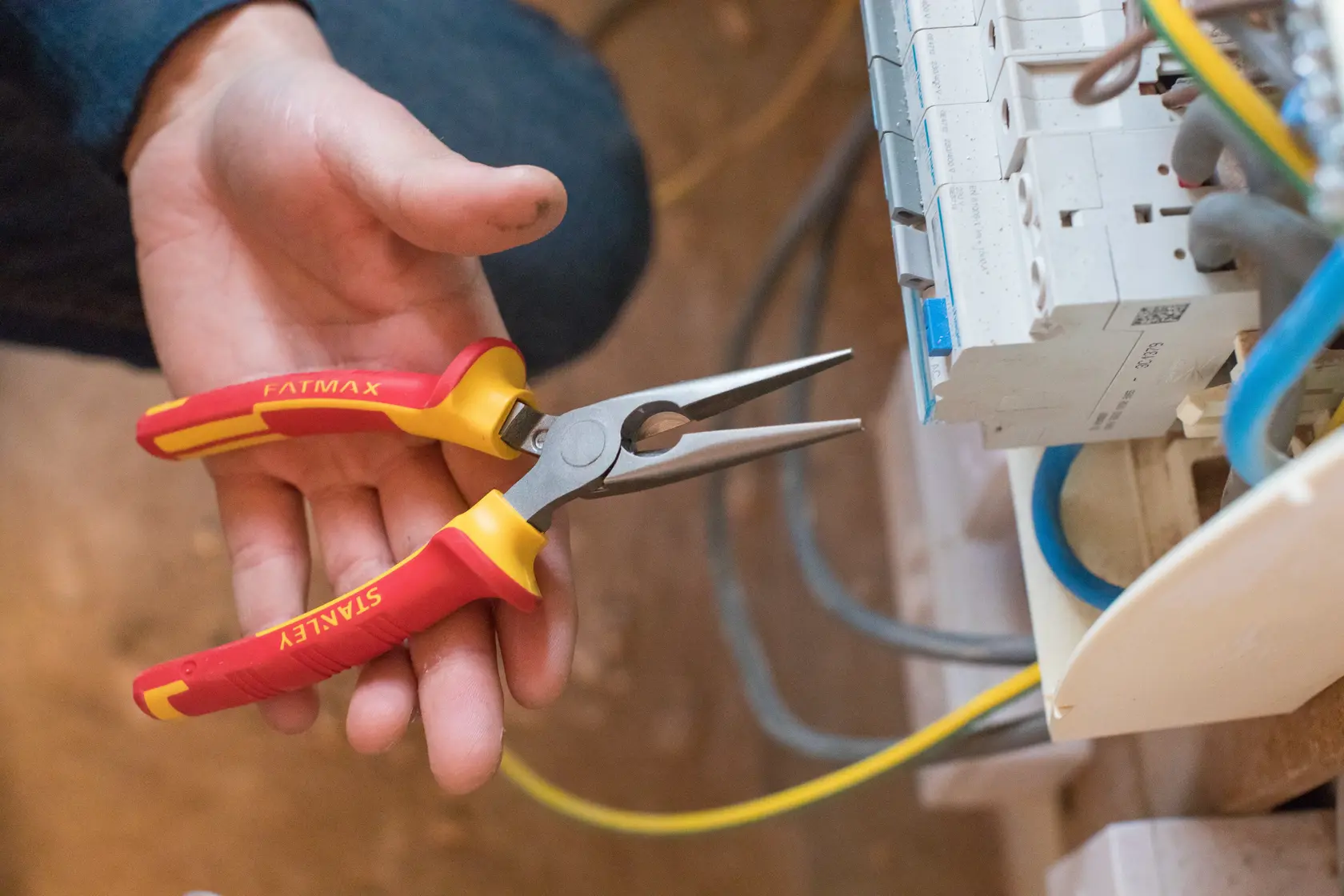 STANLEY 0-84-006 long nose pliers with red and yellow handles used for electrical work.