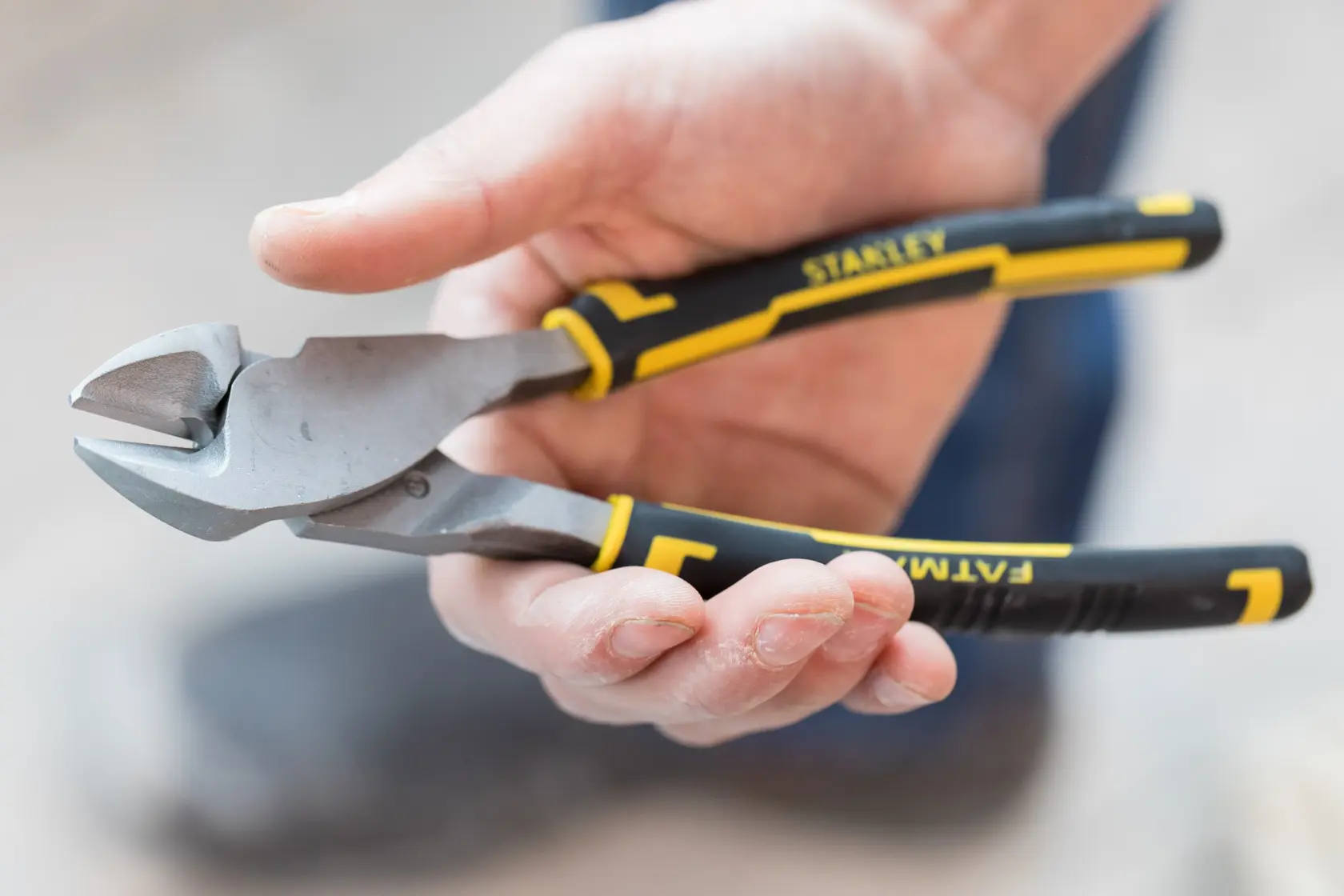 STANLEY 0-89-861 diagonal cutting pliers with black and yellow handles held in hand.