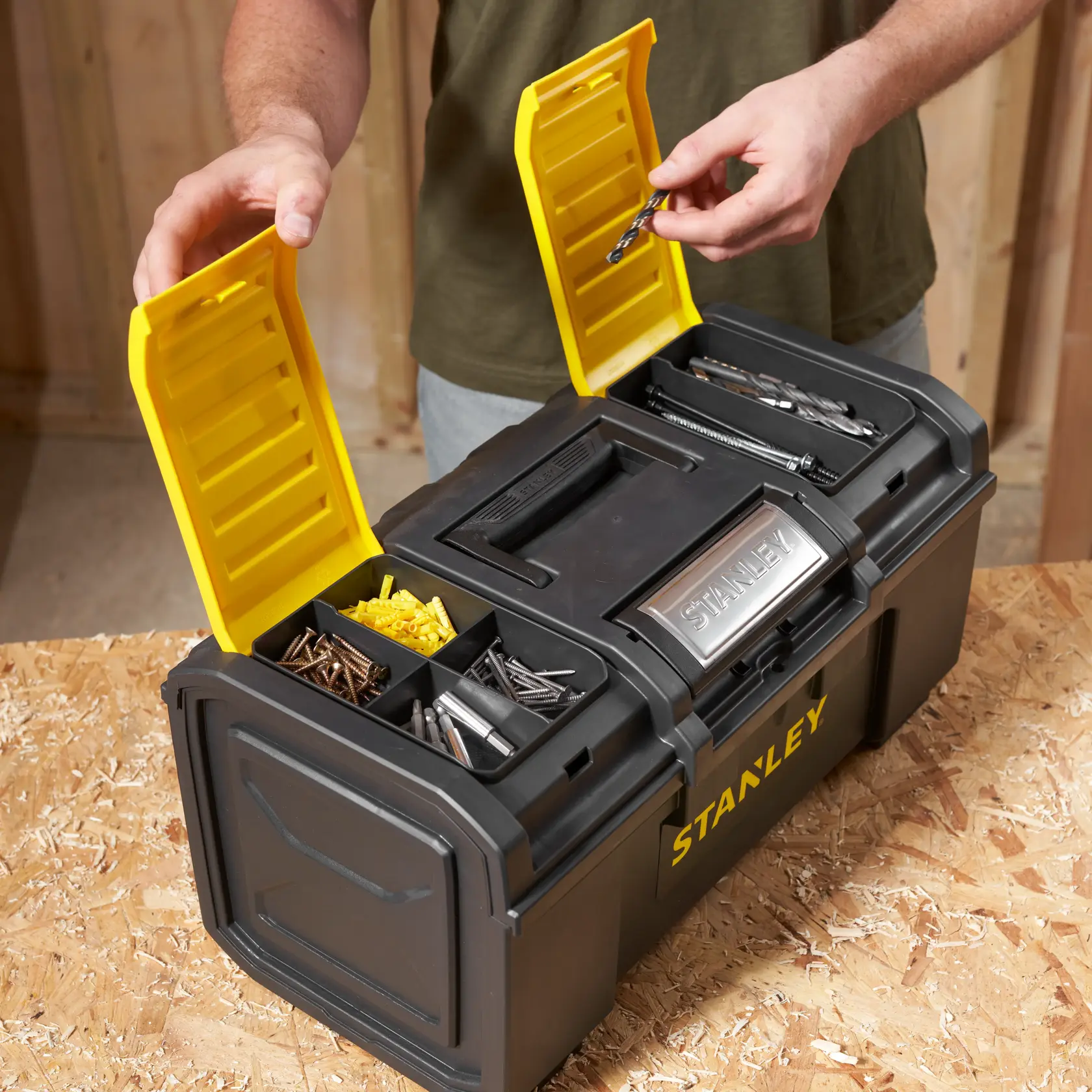 STANLEY 1-79-217 black toolbox with yellow lids, open to show compartments with screws and drill bits.