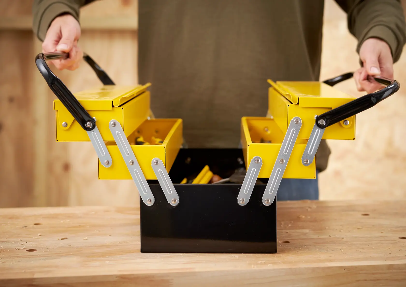 STANLEY 1-94-738 metal cantilever toolbox open on workbench, yellow and black, shown from front angle.