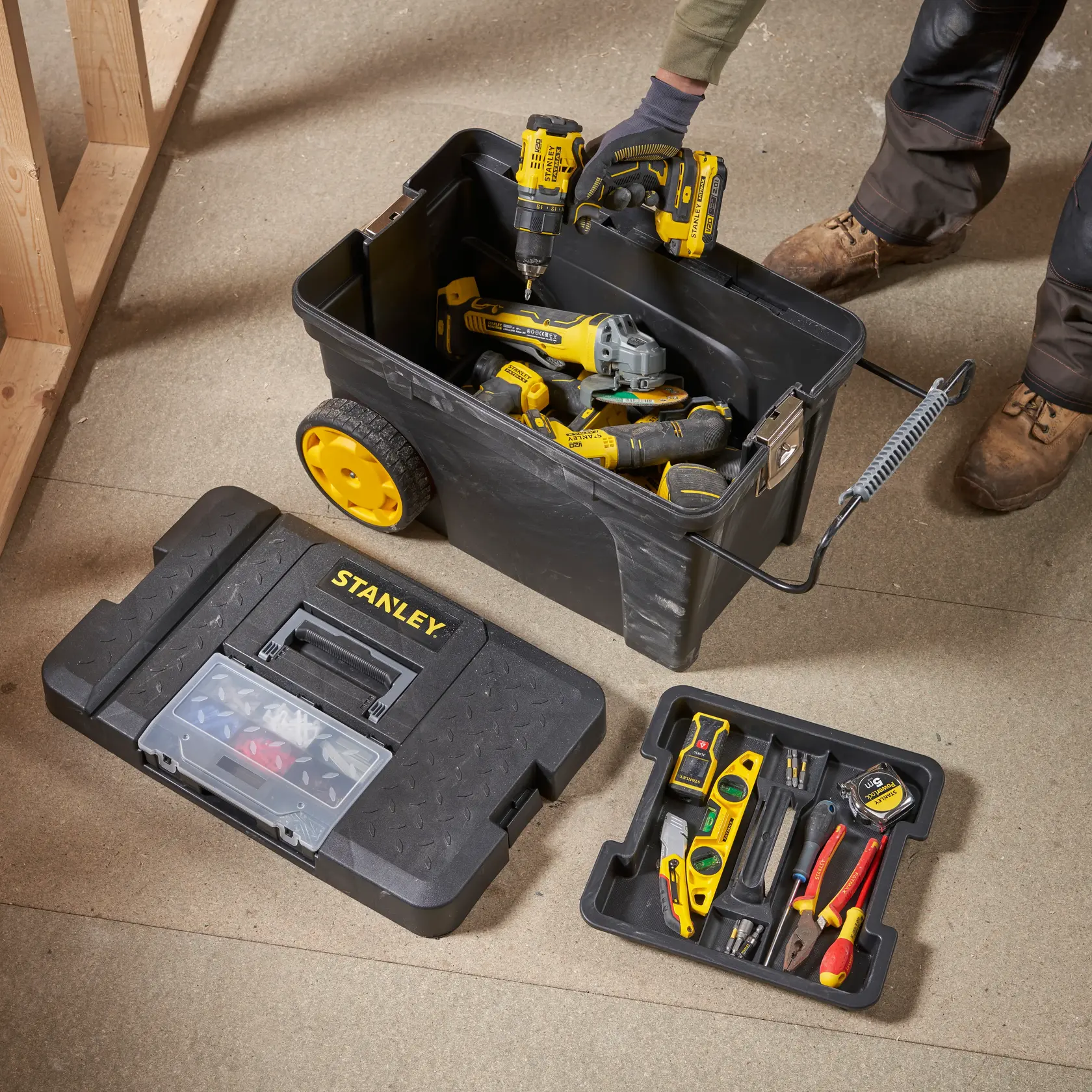STANLEY 1-97-503 tool box on wheels with hand tools, power tools, and open storage tray on floor, top view.