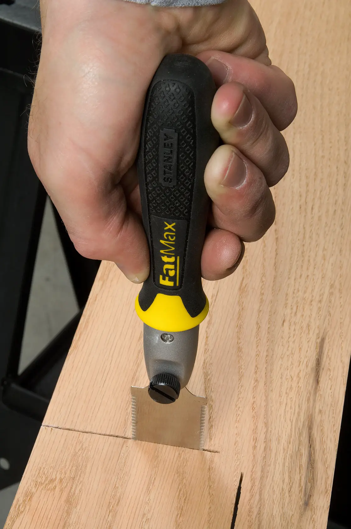 STANLEY 3-20-331 marking gauge FatMax used to scribe wood, close-up of hand holding tool.