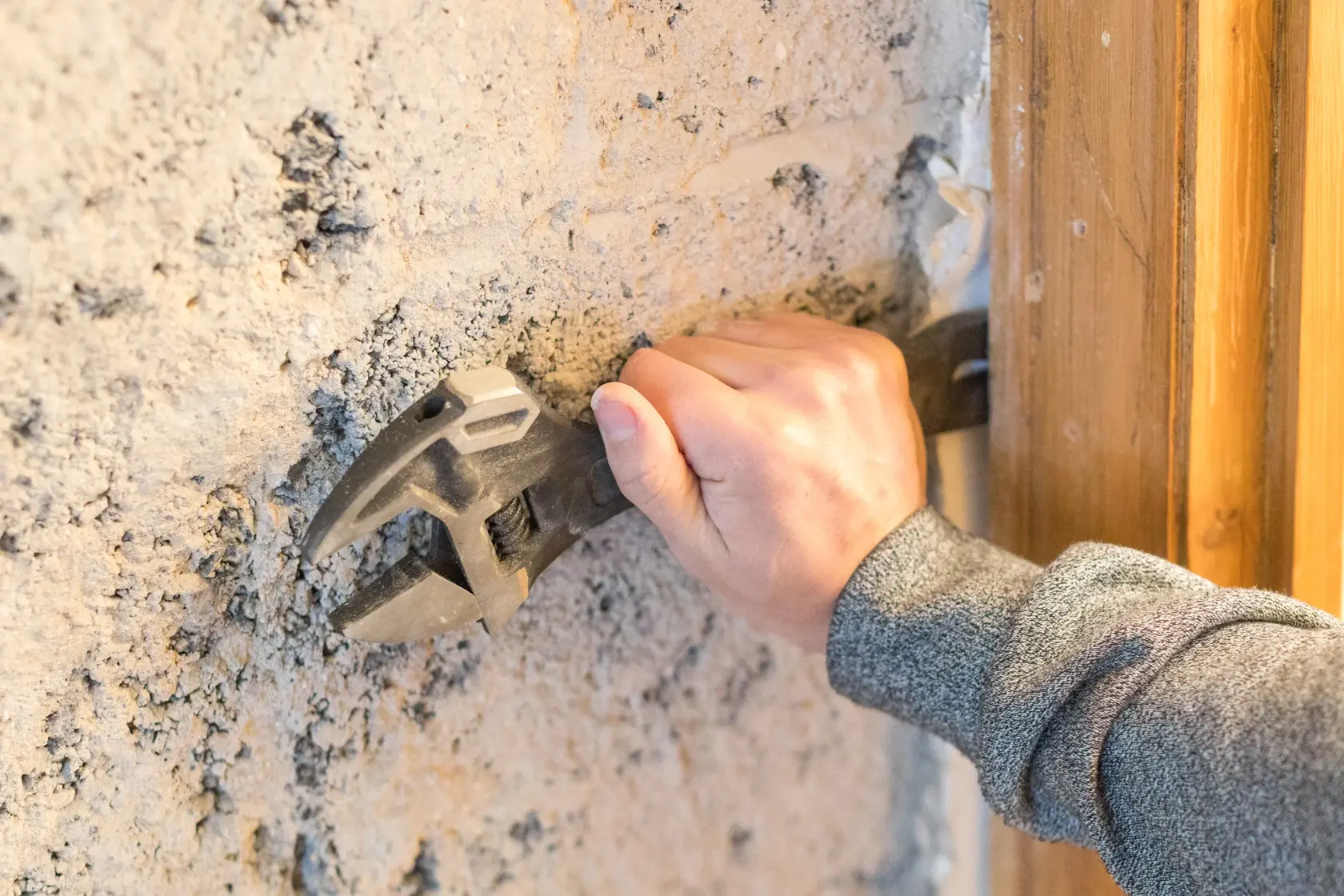 Photo of STANLEY FMHT0-75081 adjustable wrench held against a rough concrete wall.