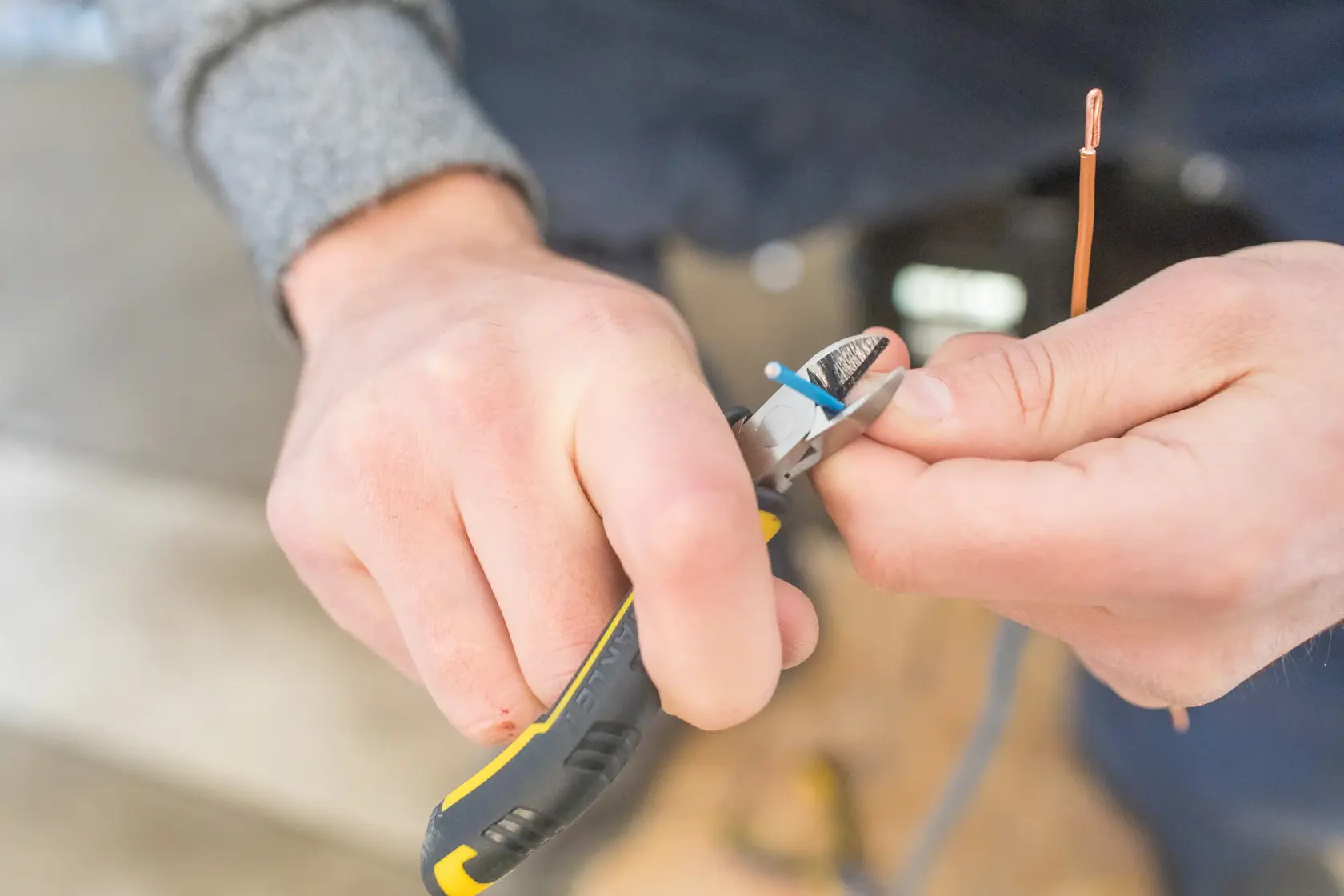 Photo of STANLEY FMHT0-80524 diagonal pliers cutting blue wire, product shown in use.