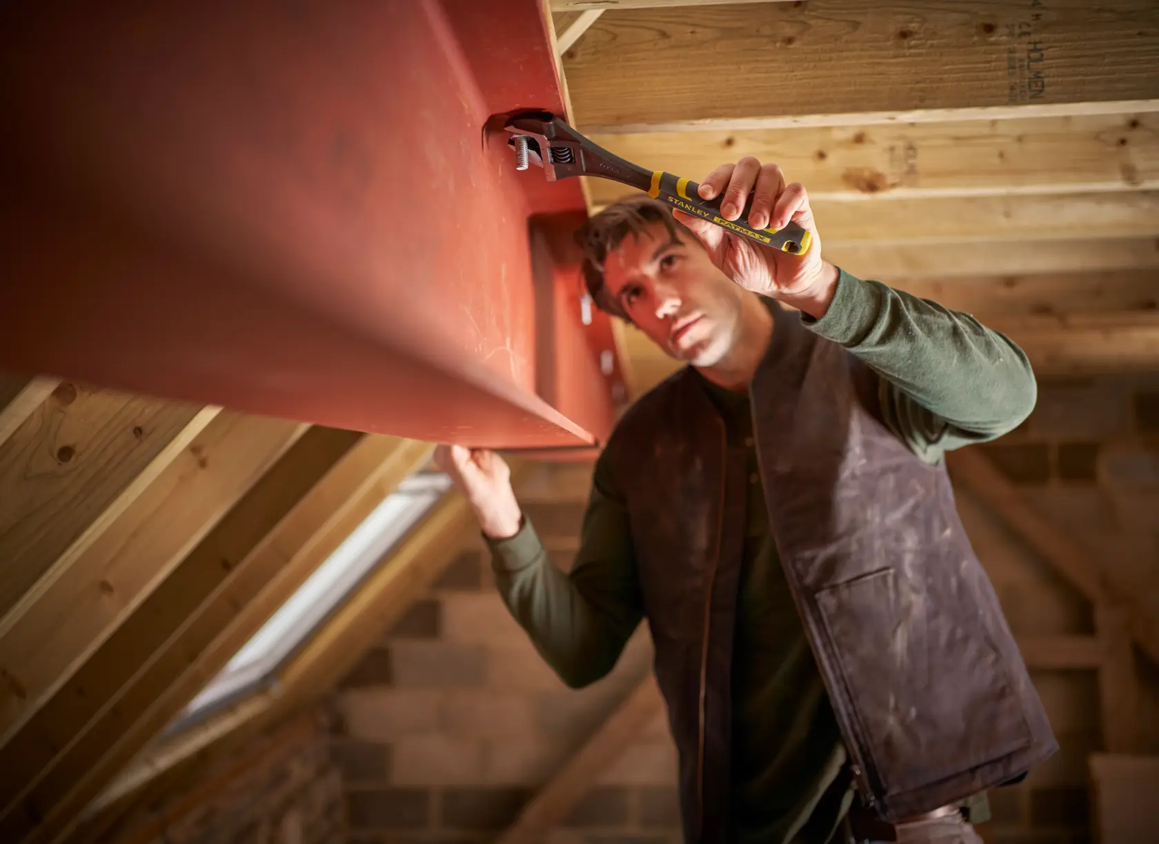 STANLEY FMHT13127-0 adjustable wrench used on a red steel beam in a loft construction setting.