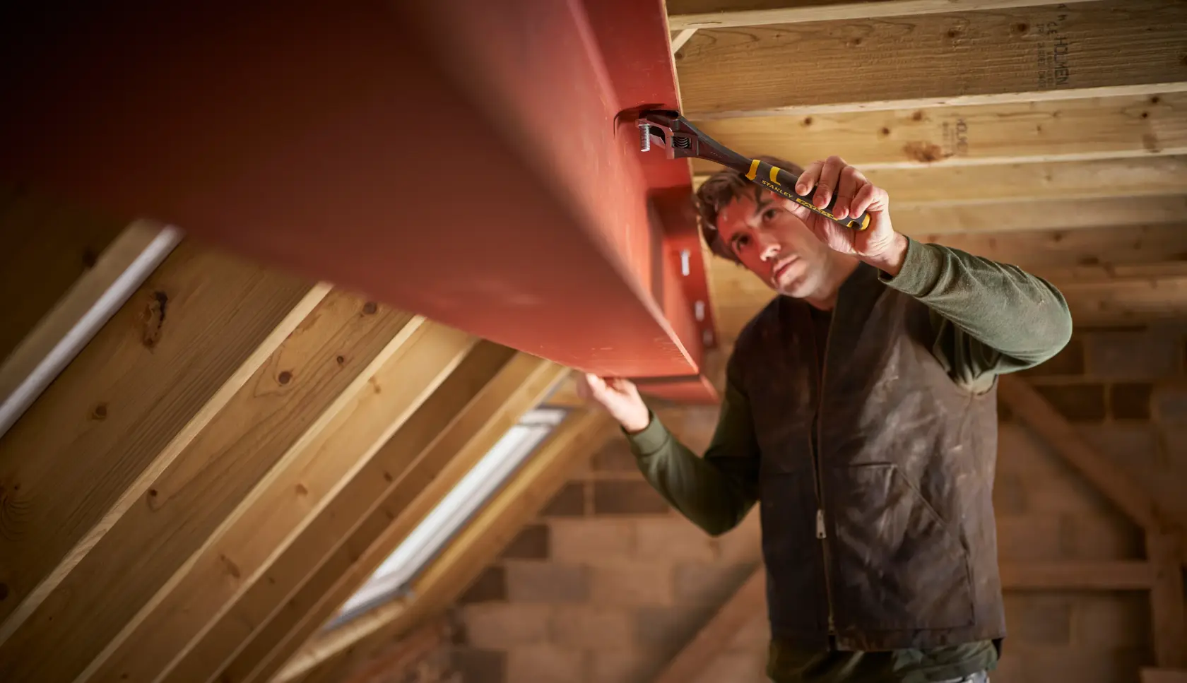 Photo of STANLEY FMHT13127-0 hand tool in use on steel beam inside wooden attic.