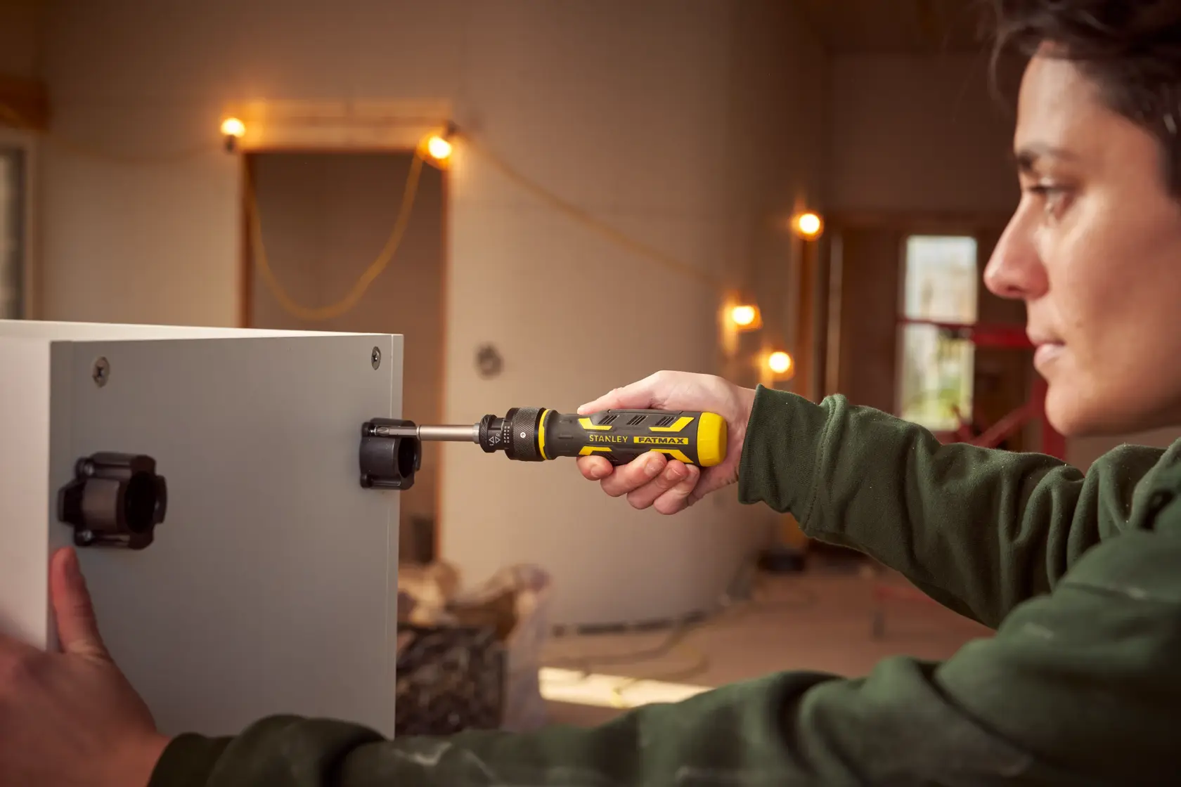 STANLEY FMHT62692-0 ratcheting screwdriver in use on cabinet in a workshop.