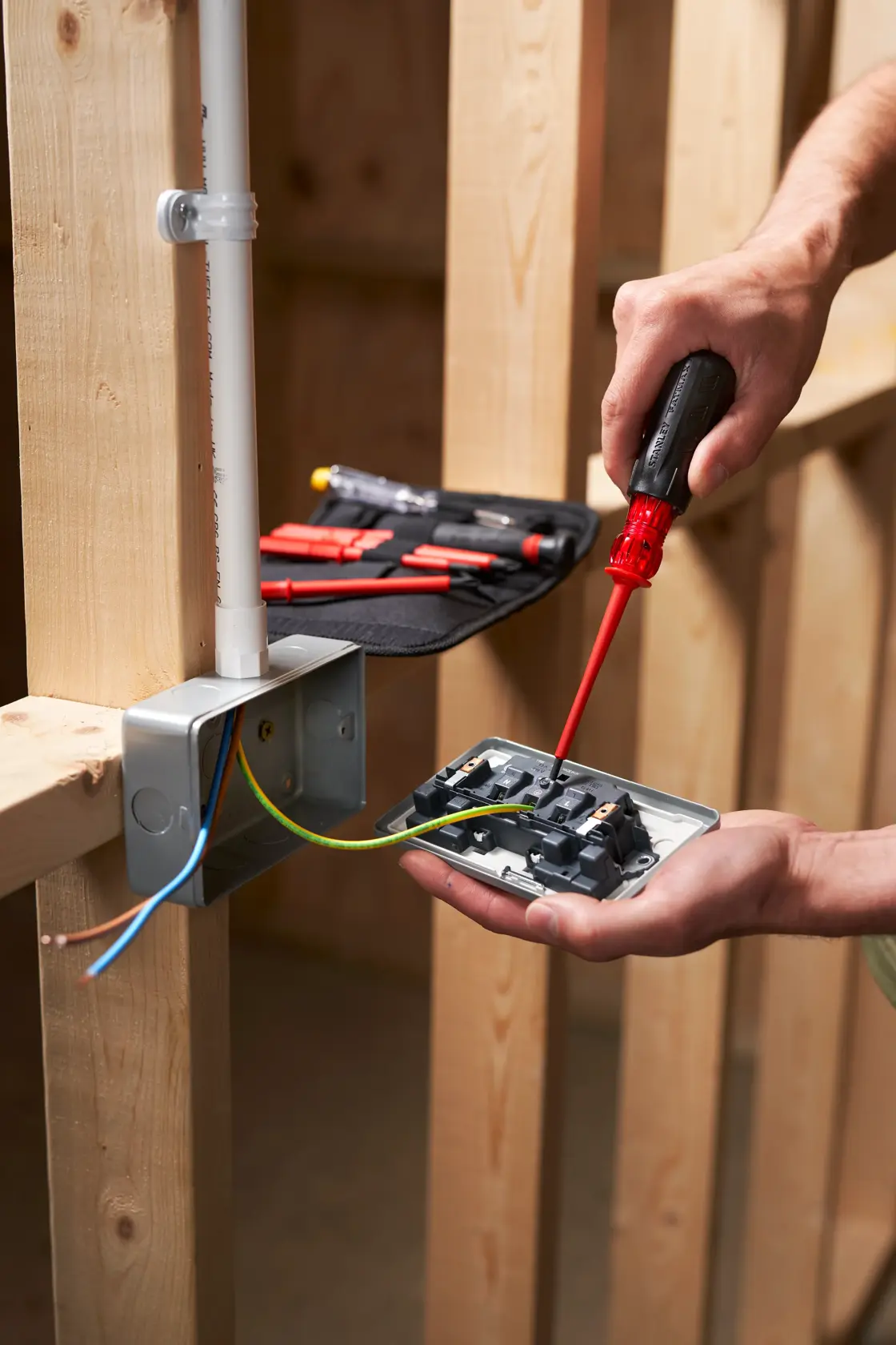 STANLEY FMHT66426-0 screwdriver in use wiring electrical outlet, photography side angle.