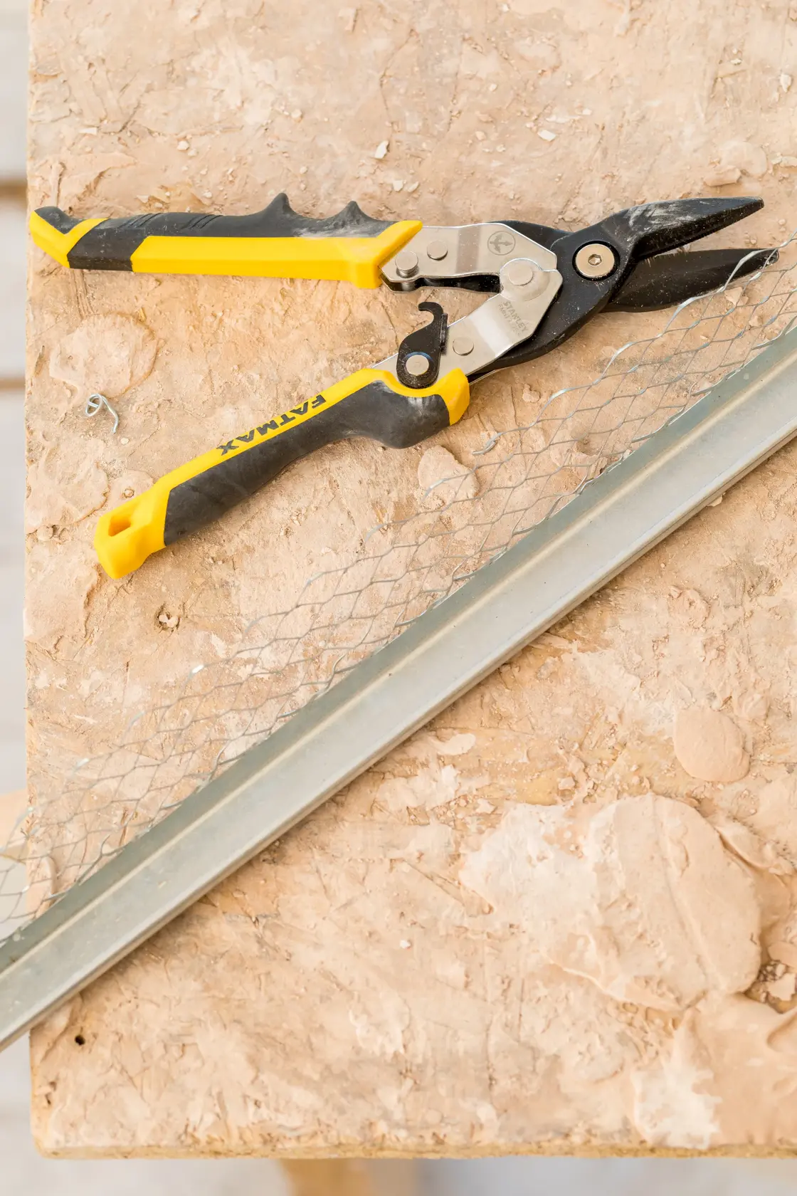 STANLEY FMHT73756-0 aviation snip with yellow and black handle on a workbench, shown from above.