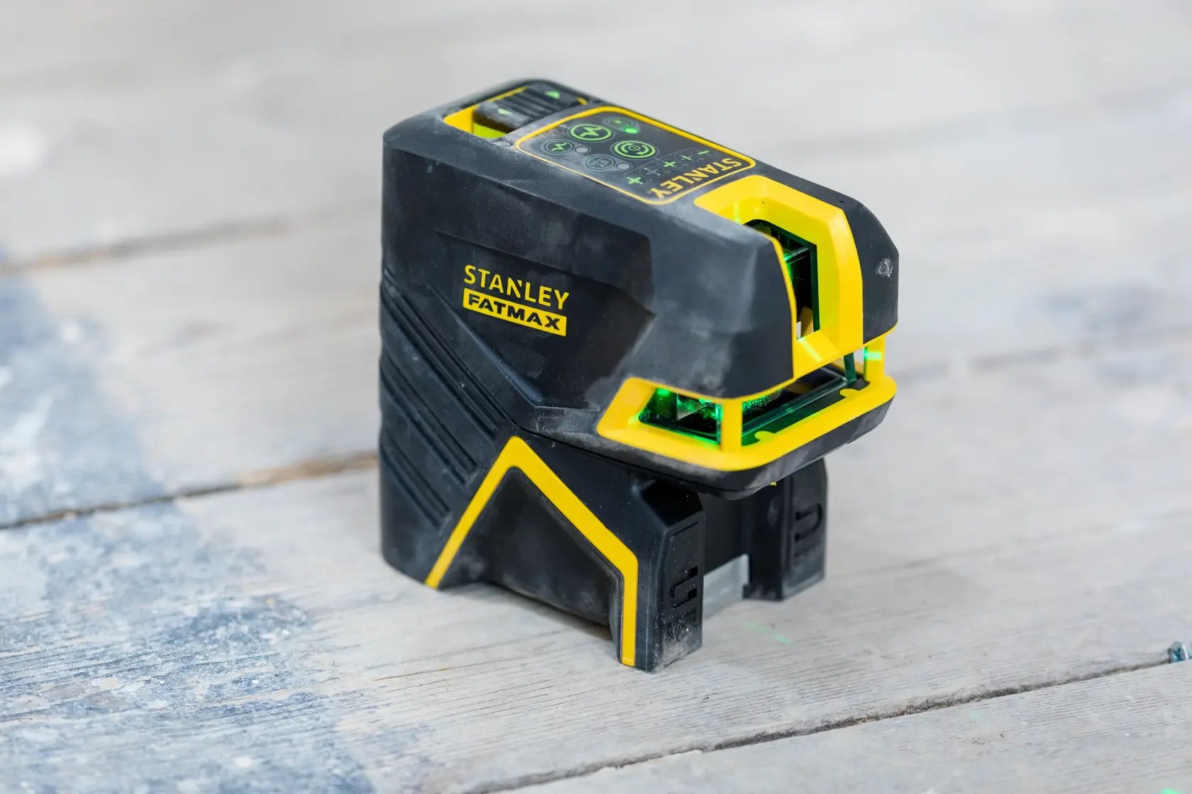 STANLEY FMHT77598-1 laser level, black and yellow, photography of tool on wooden surface.