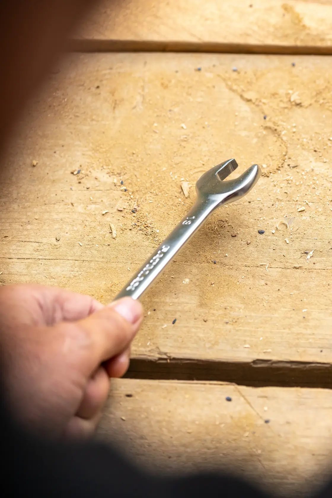 Photo of STANLEY FMMT13041-0 open-end wrench held by hand on wooden surface.