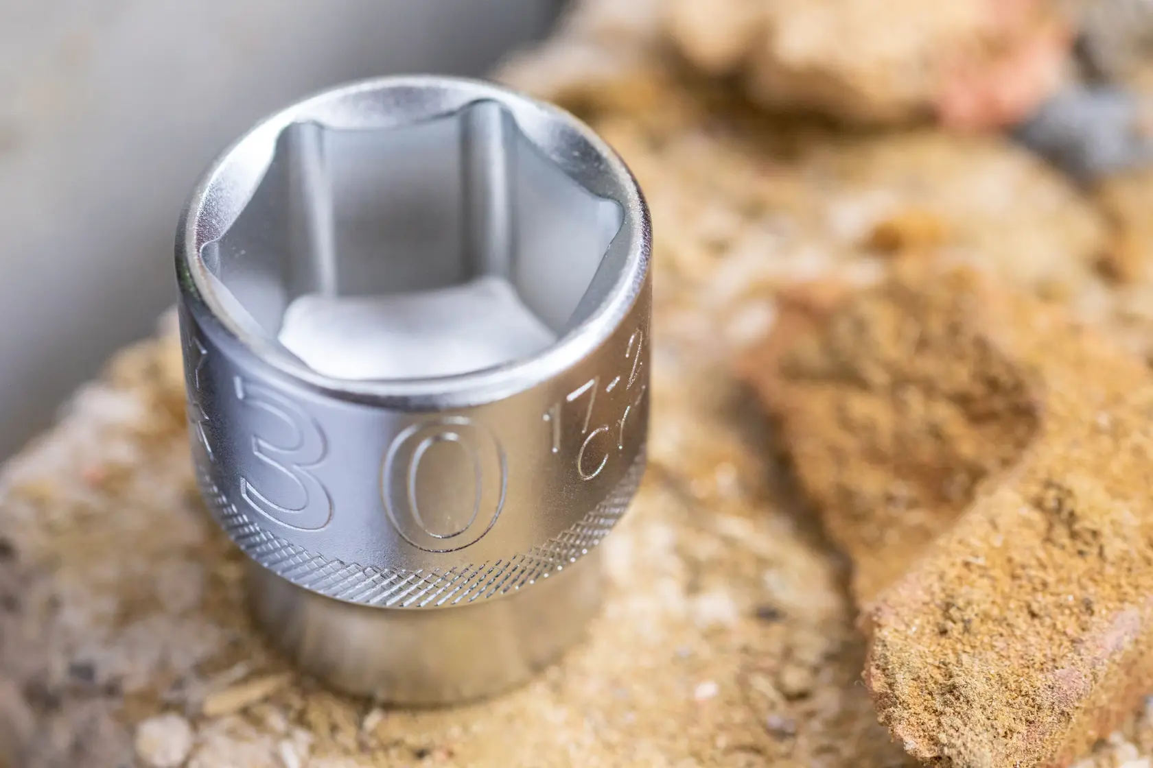 STANLEY FMMT17190-0 chrome socket on rough stone surface, close-up photo, hand tool accessory.
