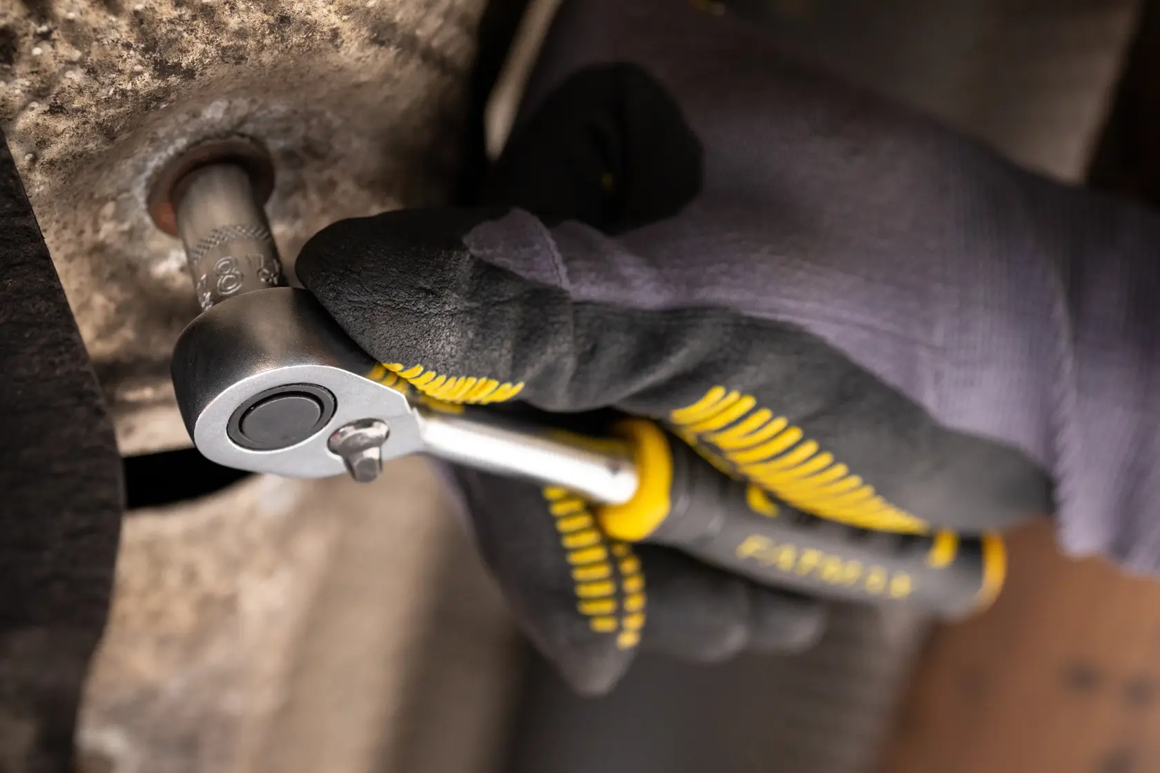 Photo of STANLEY FMMT17196-0 ratchet being used on a bolt, close-up view with gloved hand.