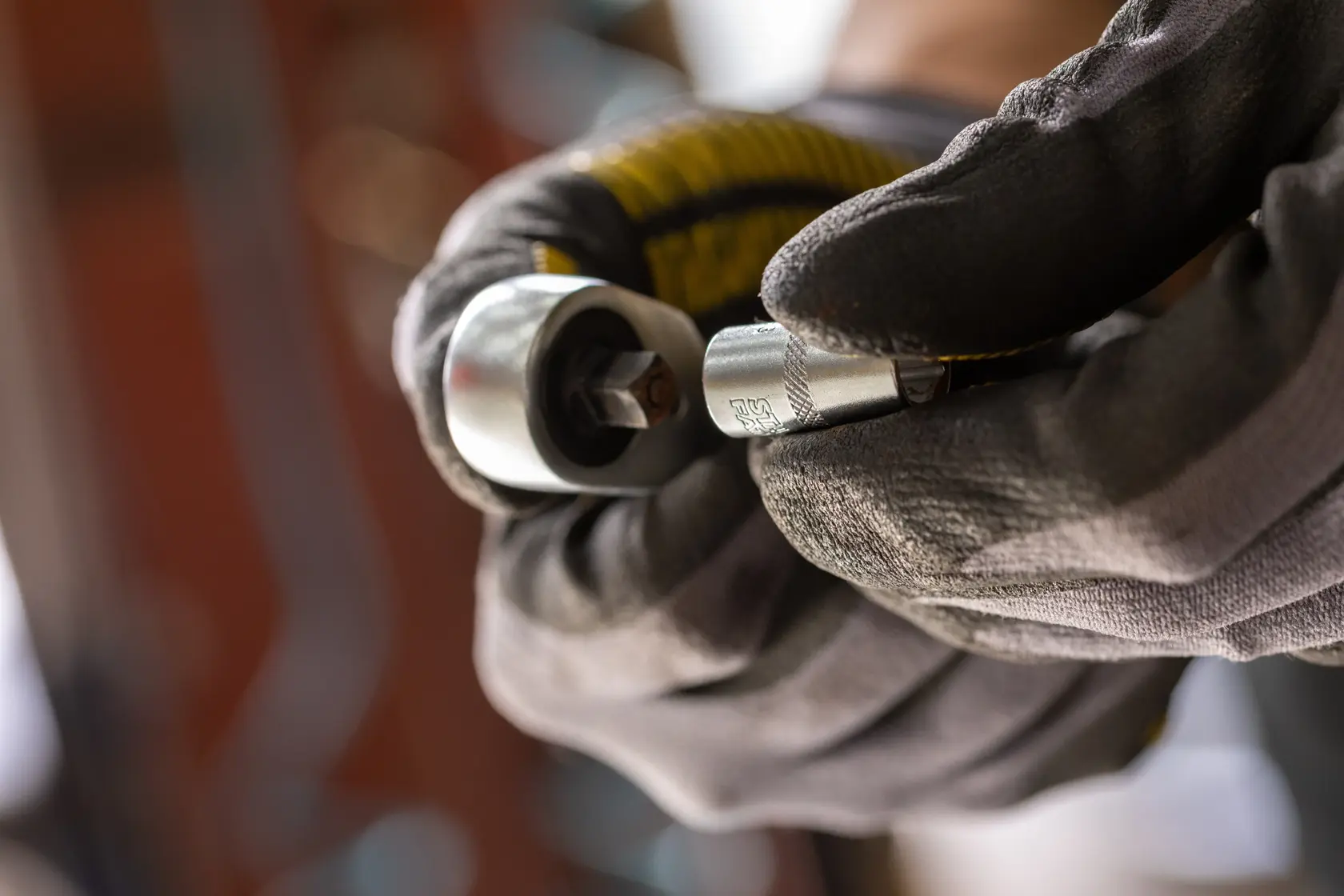 Photo of STANLEY FMMT17196-0 socket wrench in gloved hand, close-up view, silver finish.