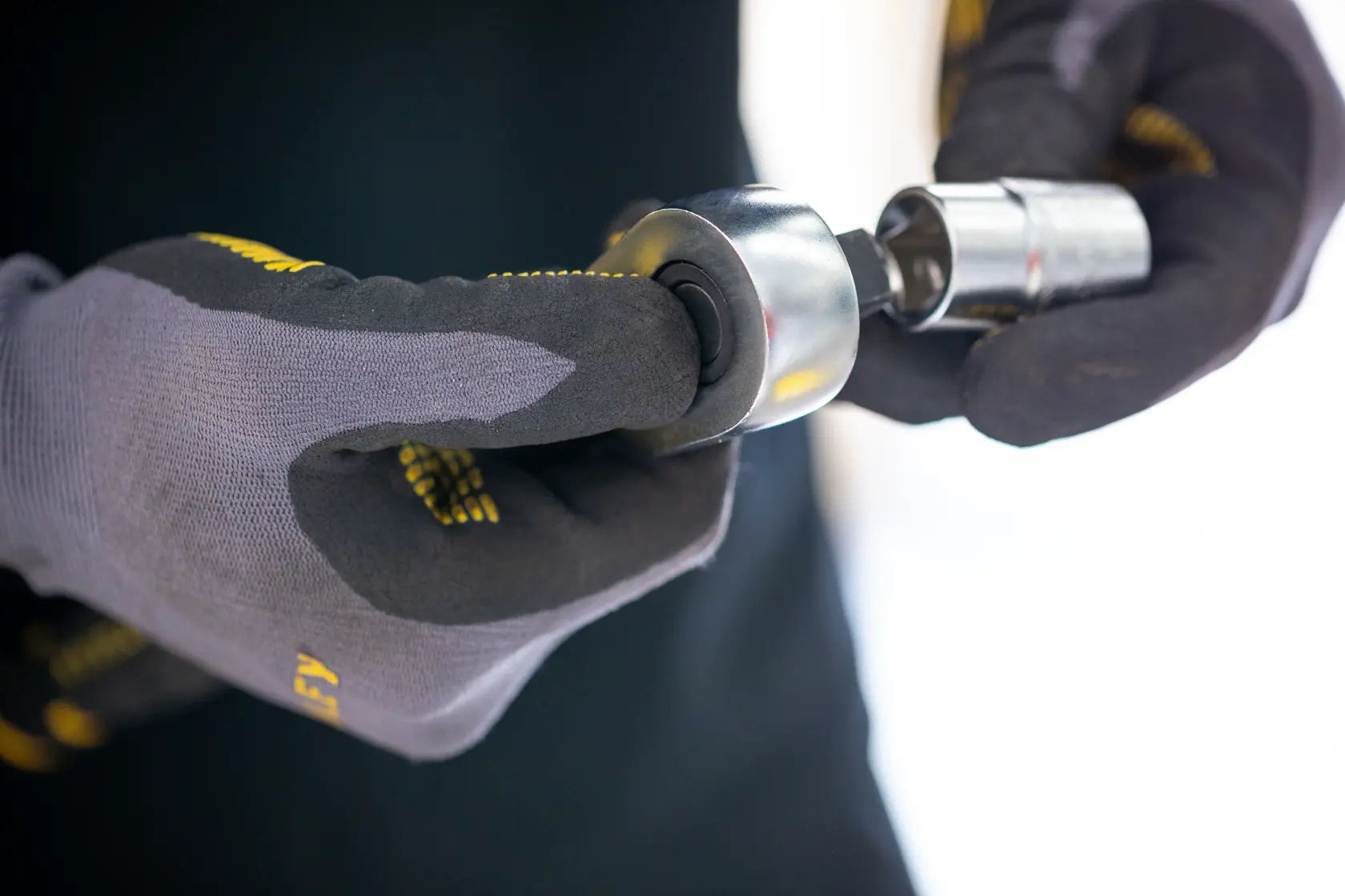 STANLEY FMMT17221-0 socket tool held by gloved hands, close-up photography.