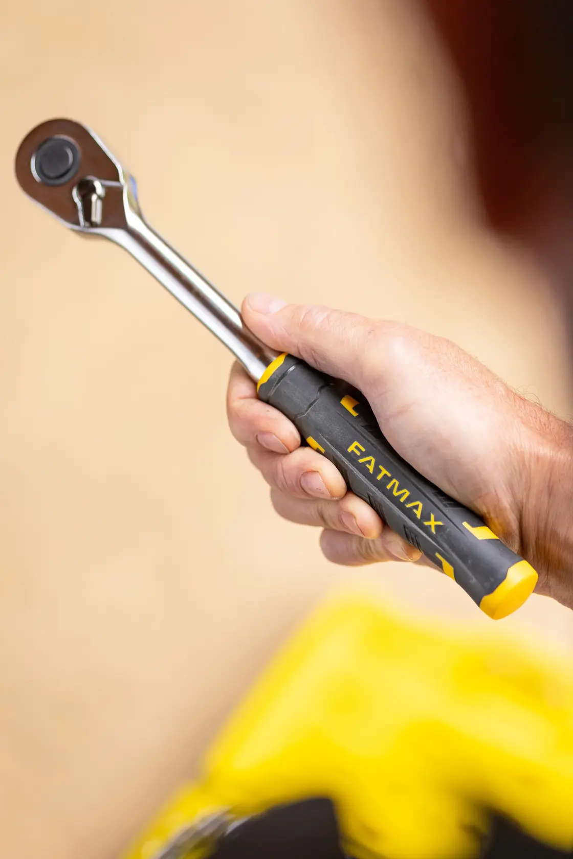 Photo of STANLEY FMMT82678-0 FATMAX ratchet wrench with black and yellow handle, held in hand.