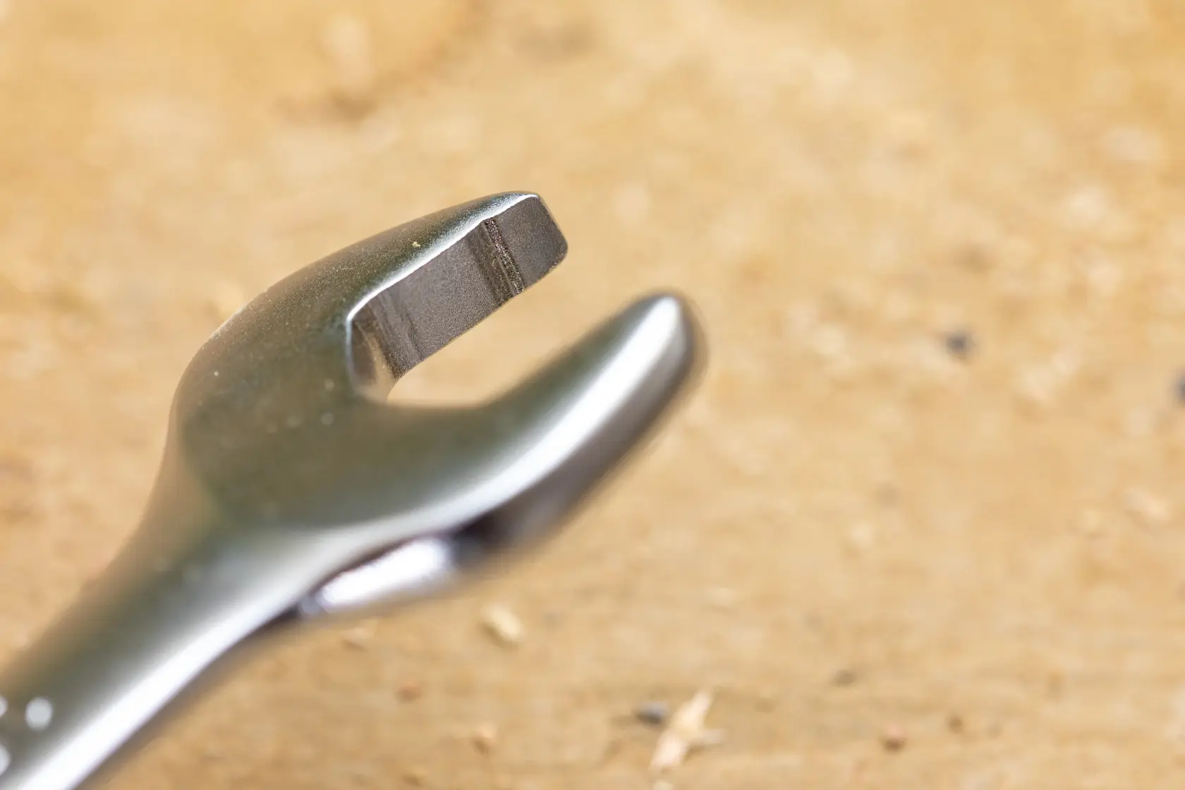 STANLEY FMMT82845-0 photography of open-end wrench head on wood surface, close-up angle.