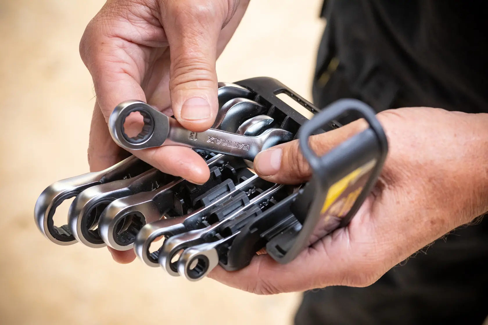 STANLEY FMMT82900-0 ratcheting combination wrench set held in hands, close-up outdoor view.