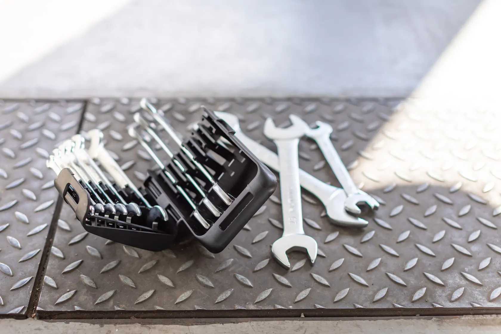 STANLEY FMMT82901-0 wrench set in black case with loose wrenches on textured metal floor, angled view.