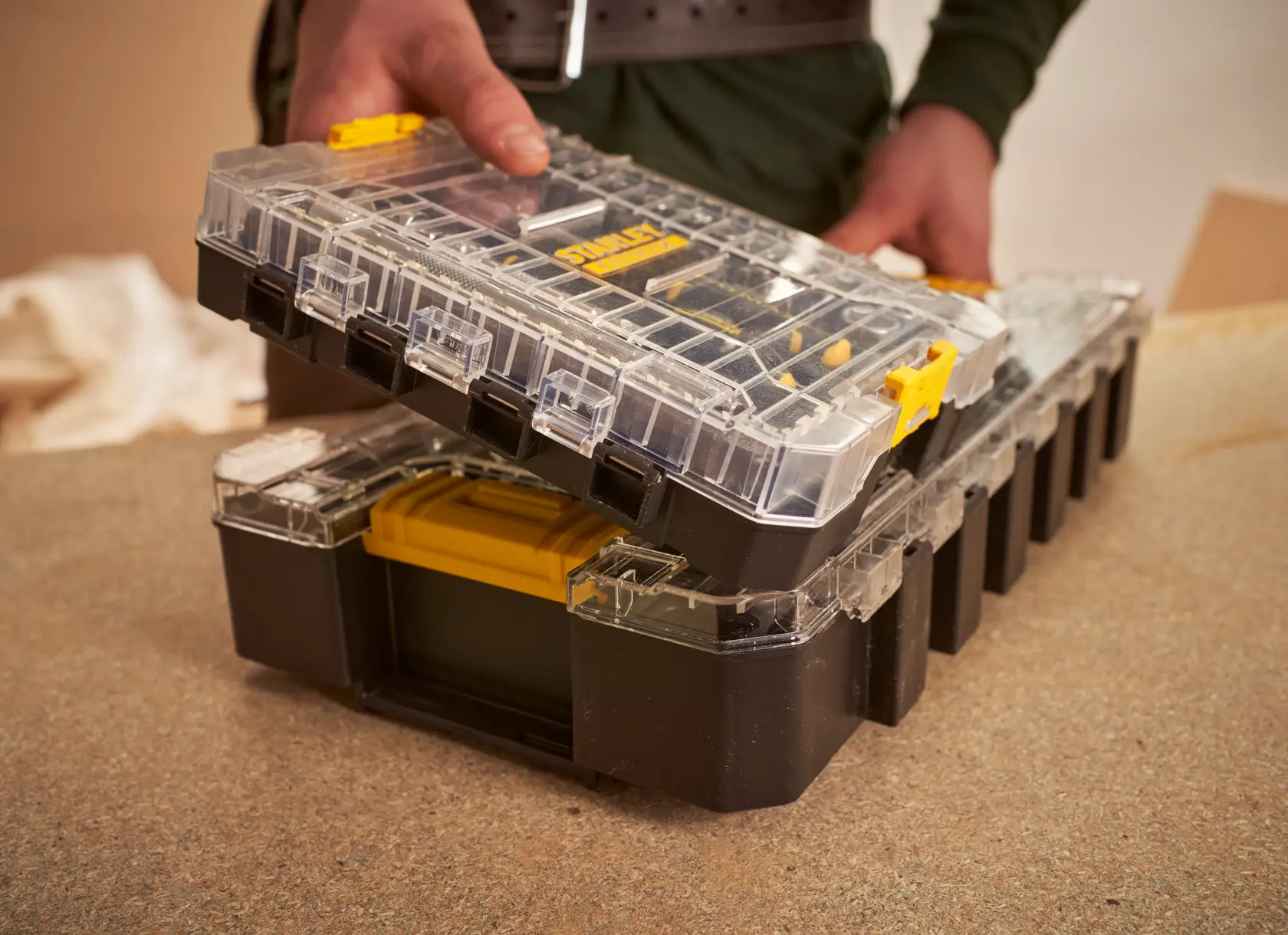 STANLEY FMMT98101-0 organizer with clear lid, yellow latch, opened on a workbench.