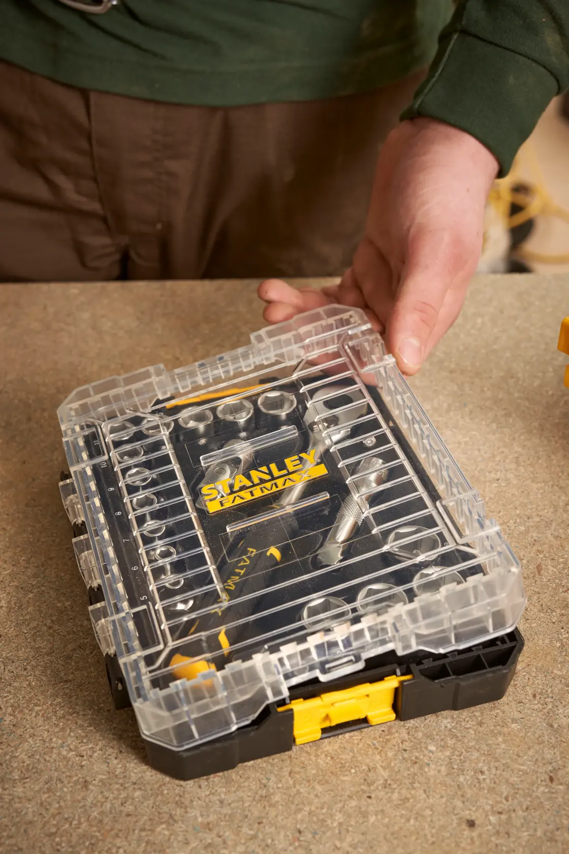 Photo of STANLEY FMMT98102-0 ratchet socket set in clear plastic case on workbench.