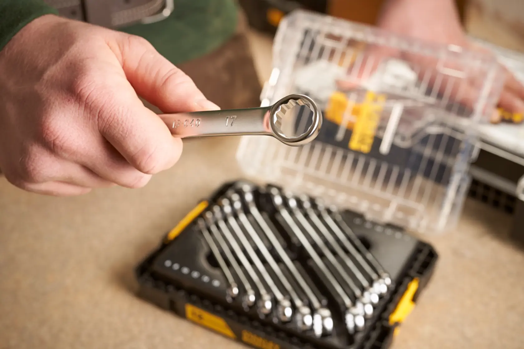 STANLEY FMMT98104-0 combination wrench held above wrench set in black and yellow case, close-up photo.