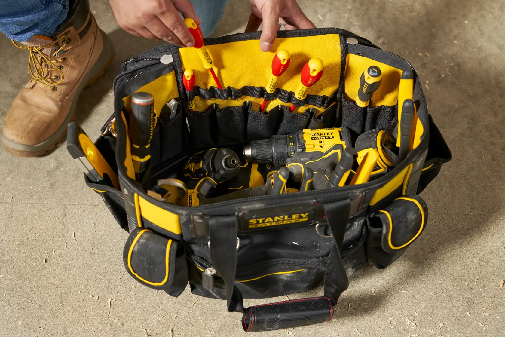 STANLEY FMST1-70749 tool bag top view with assorted hand tools and power tools, black and yellow fabric.