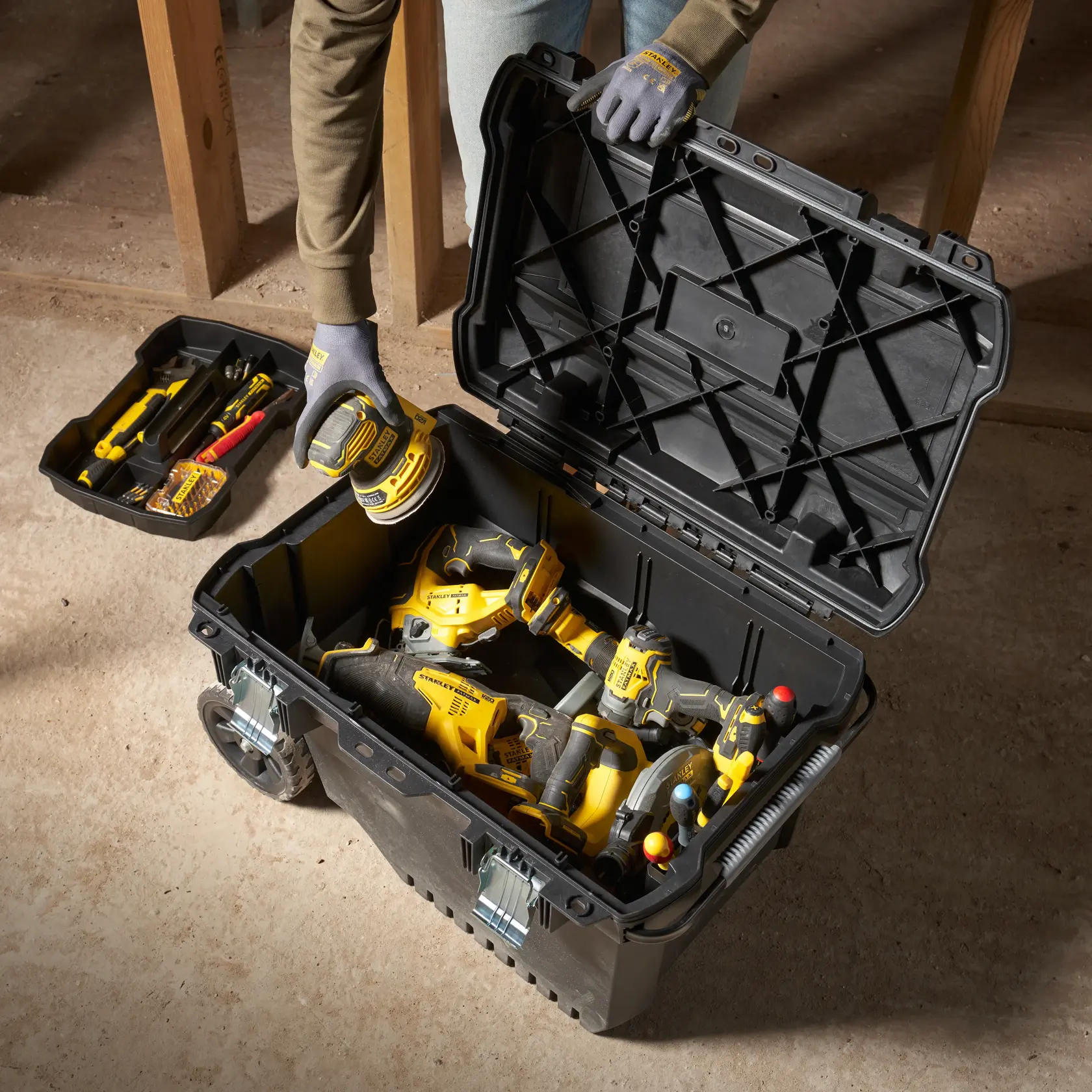 STANLEY FMST1-73601 toolbox open with various power tools inside, top view on workshop floor.