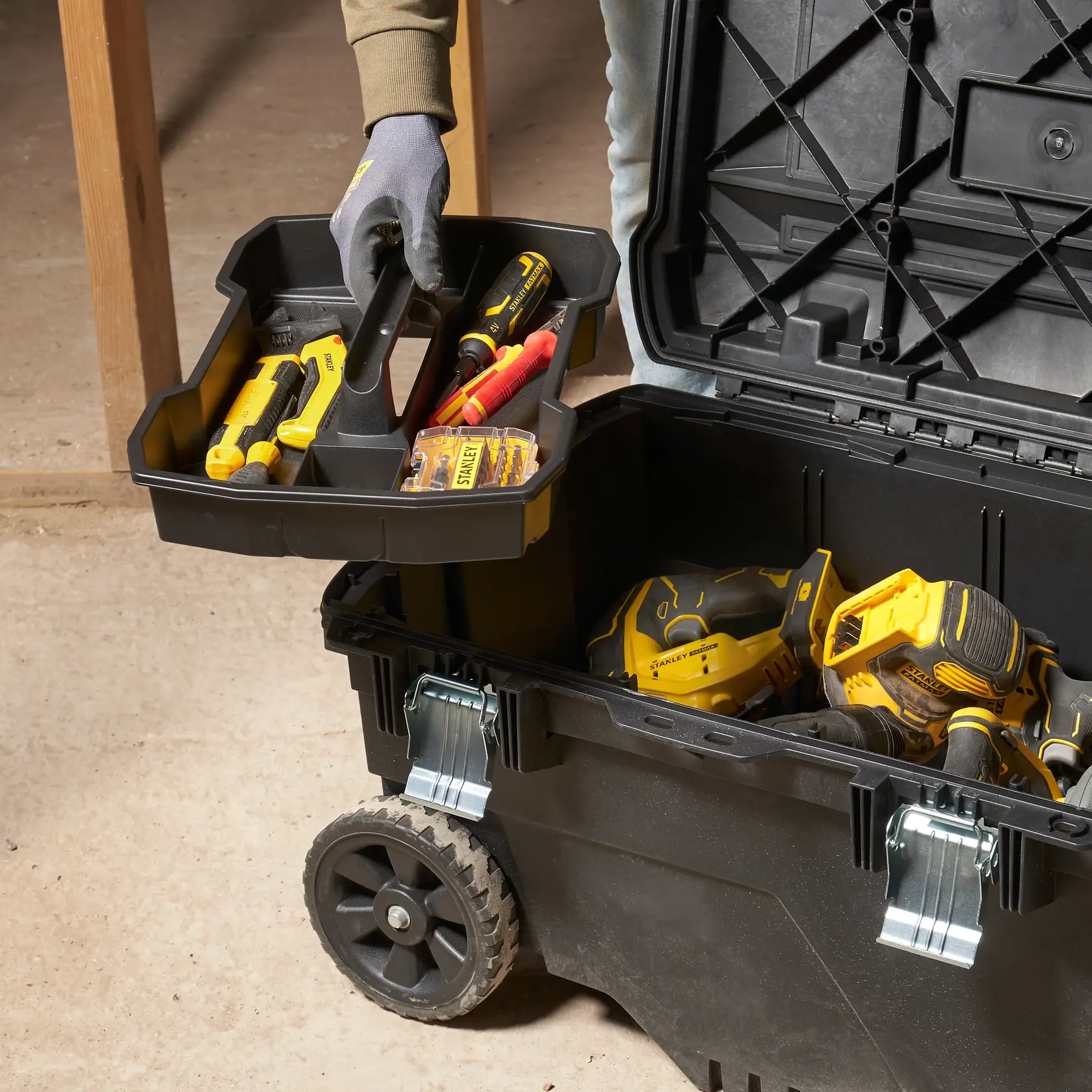 STANLEY FMST1-73601 rolling toolbox with tray, filled with tools, photographed from above in workshop setting.