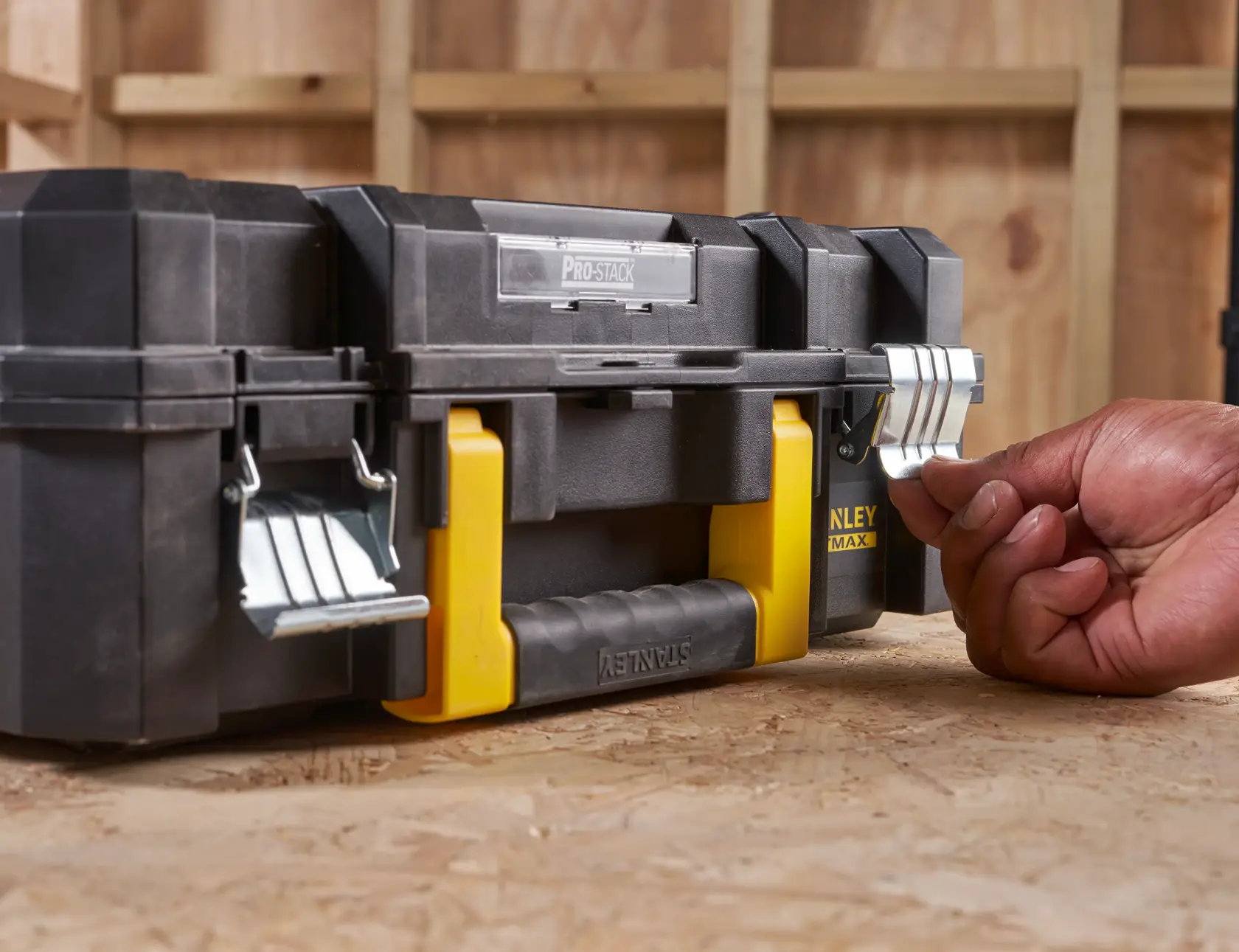 Photo of STANLEY FMST1-75502 black and yellow toolbox with metal latches on a workbench.
