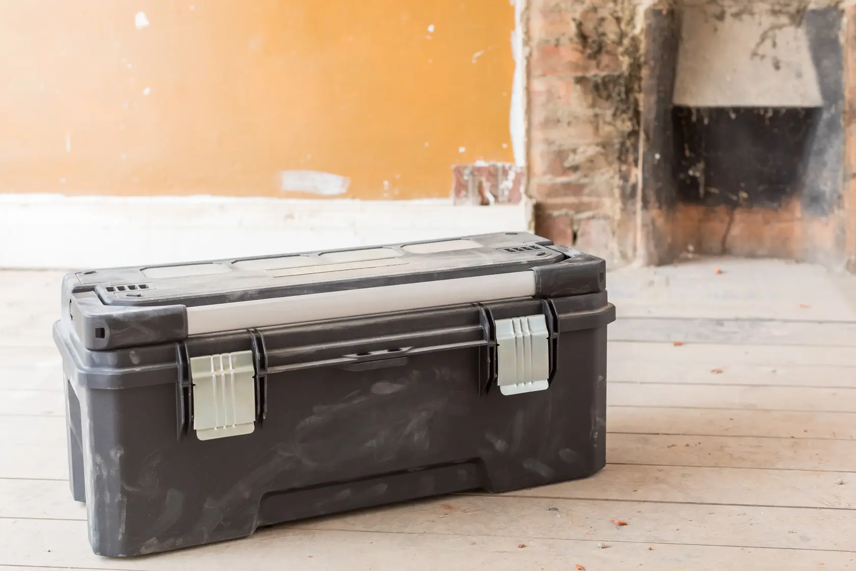 STANLEY FMST1-75791 black toolbox with metal latches, shown on wooden floor, front angle.