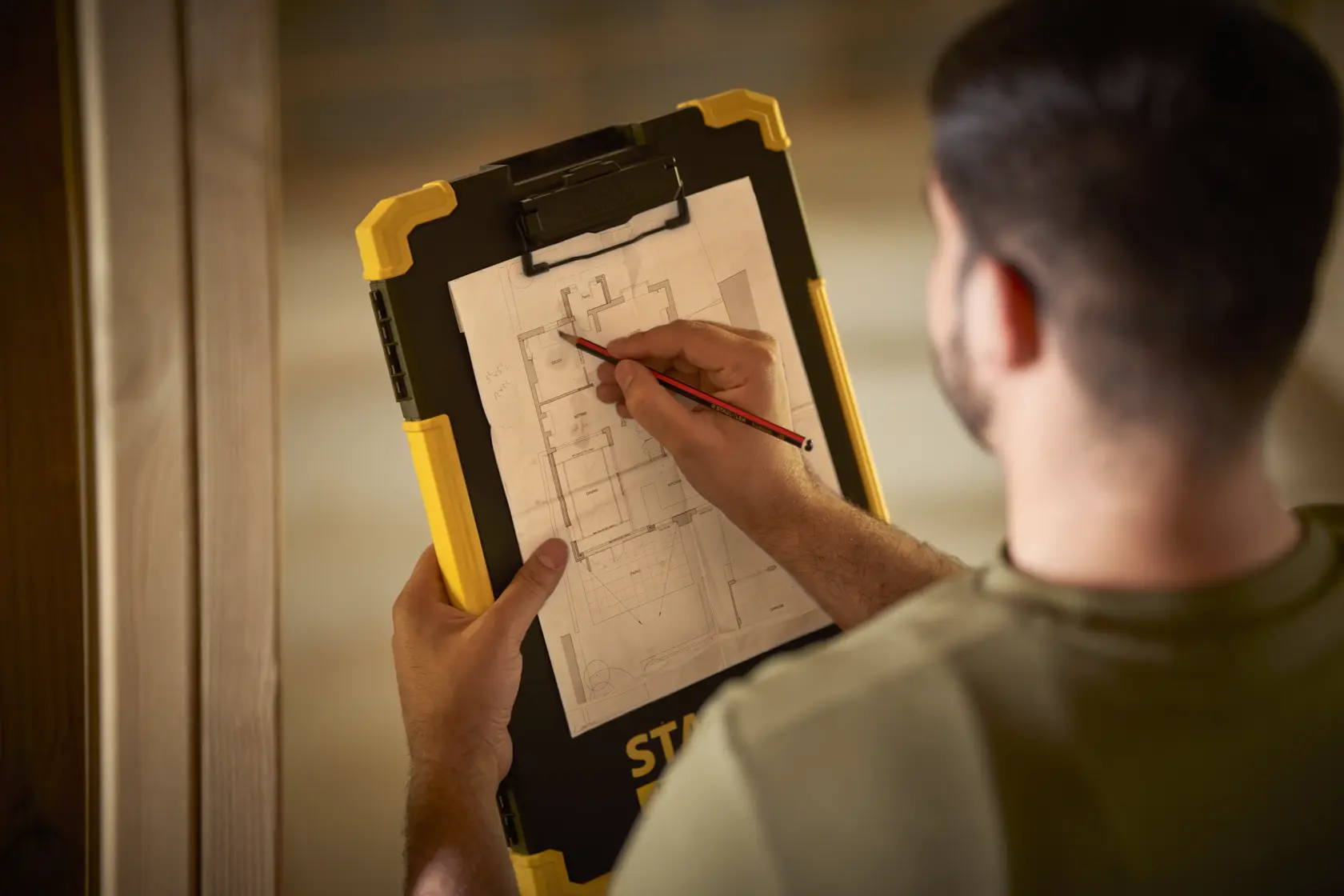 STANLEY FMST82721-1 clipboard held by person sketching on architectural plan, product photography.