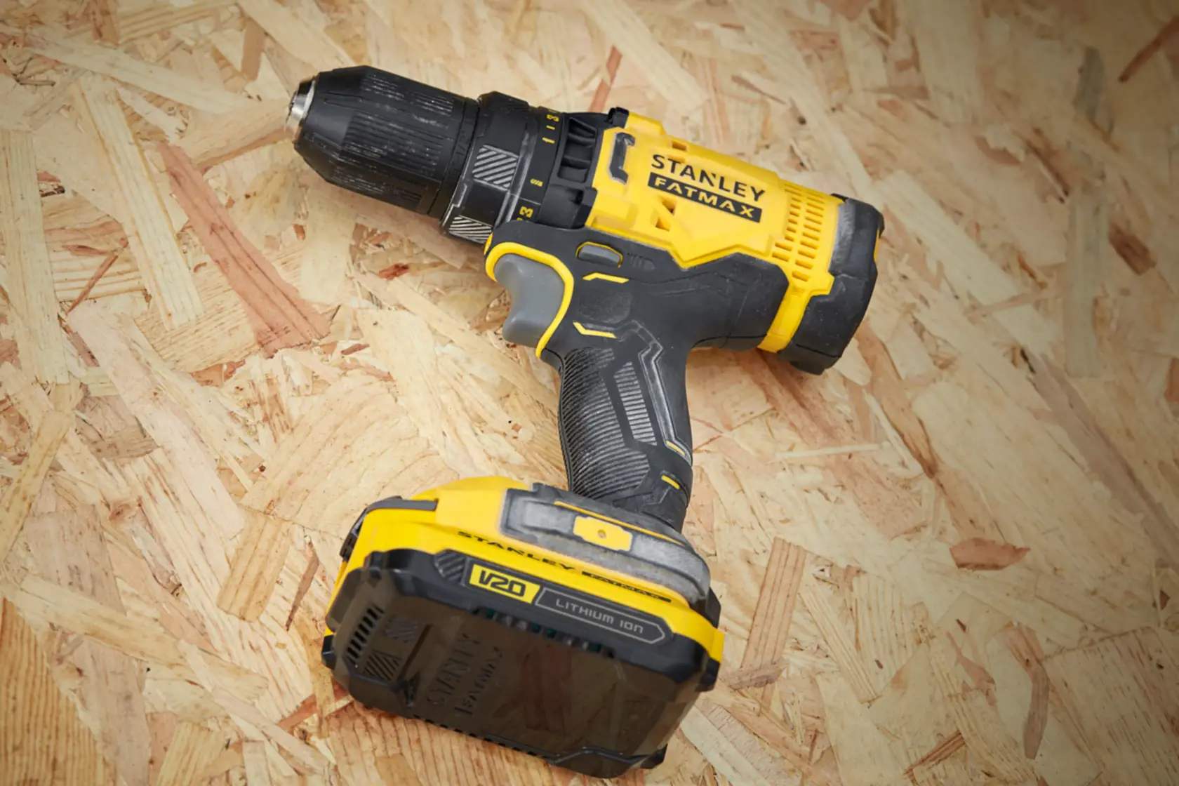 STANLEY SFMCD700C2S cordless drill driver with yellow and black body, shown on wooden surface.