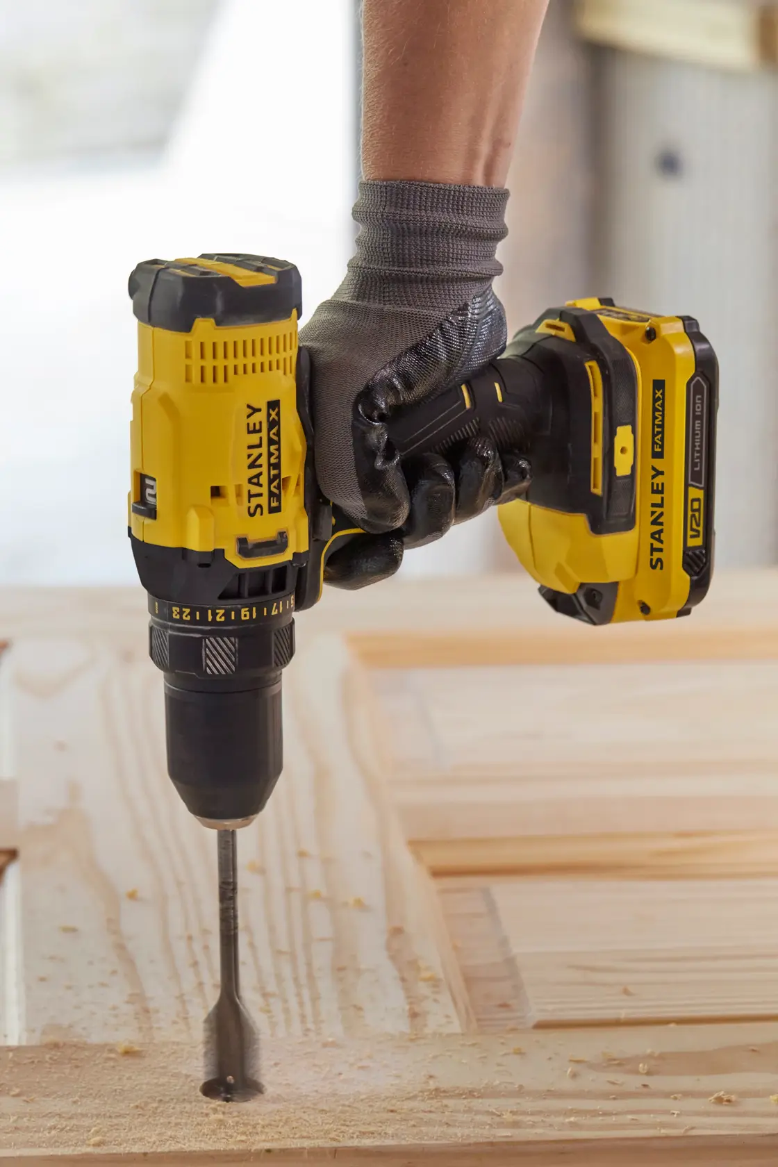 STANLEY SFMCD700C2S cordless drill in use, drilling into wood, close-up side angle.