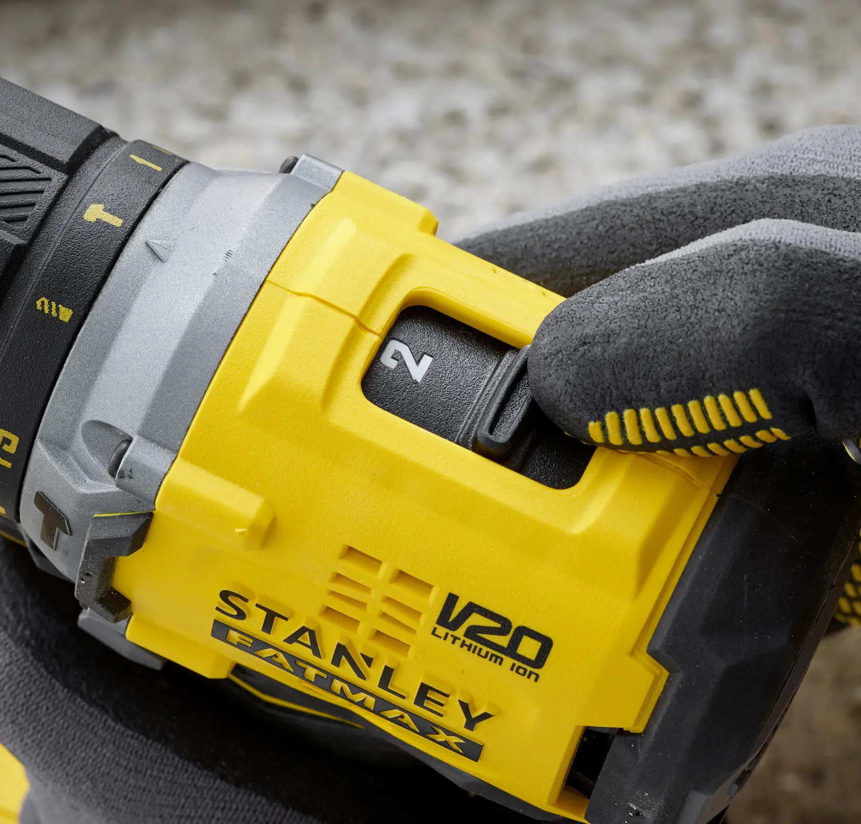Close-up of STANLEY SFMCD715M2K power drill speed selector, yellow and black, with glove adjusting switch.