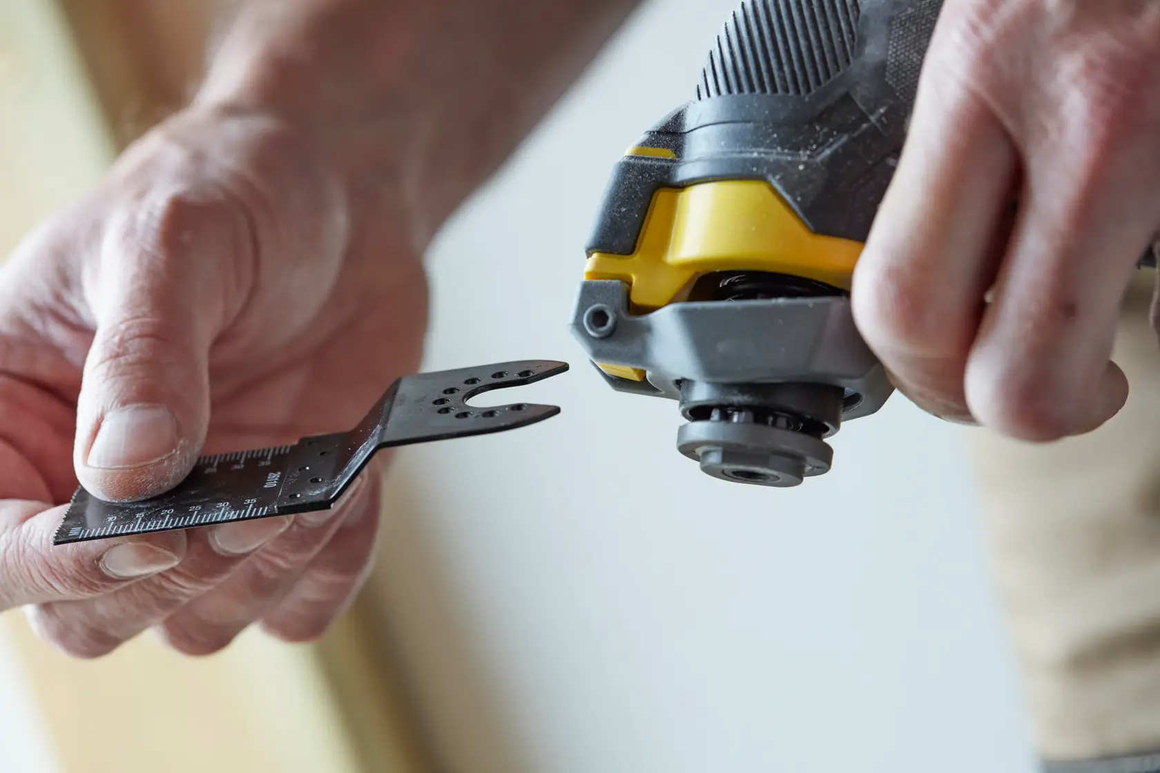 STANLEY SFMCE500B oszillierendes Multifunktionswerkzeug Nahaufnahme, Hand befestigt Klingenaufsatz.