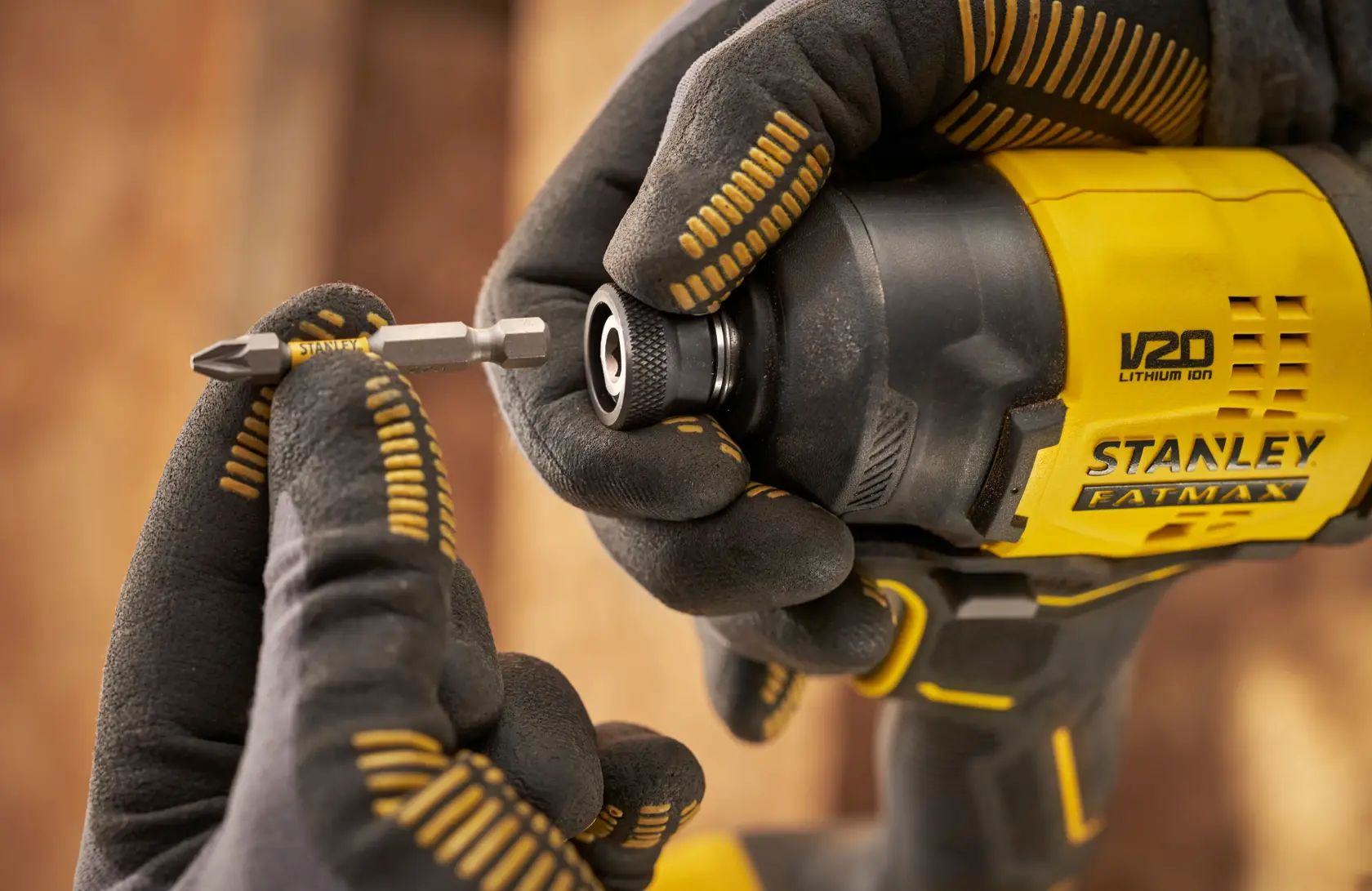 STANLEY SFMCF811D1T impact driver close-up with bit being inserted, photography of tool in gloved hands.