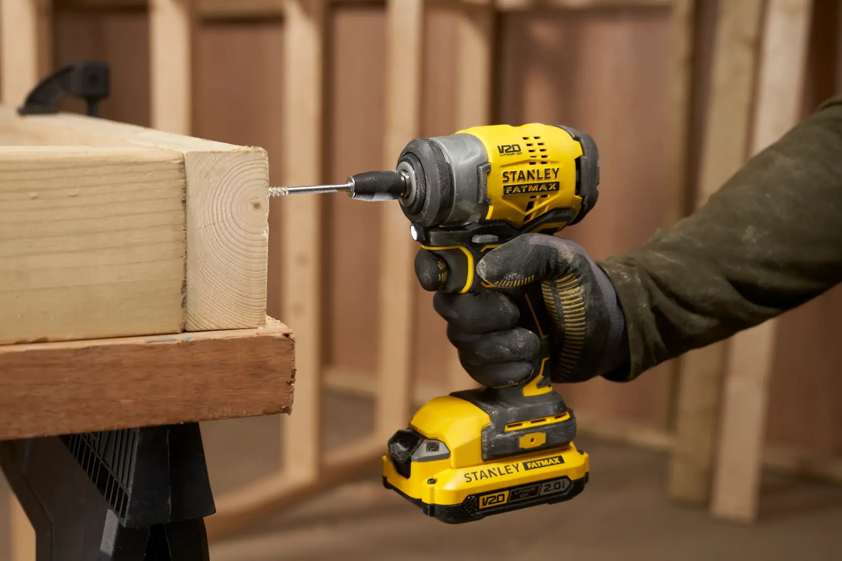 STANLEY SFMCF910B avvitatore a impulsi giallo e nero, mentre fora il legno, vista laterale ravvicinata.