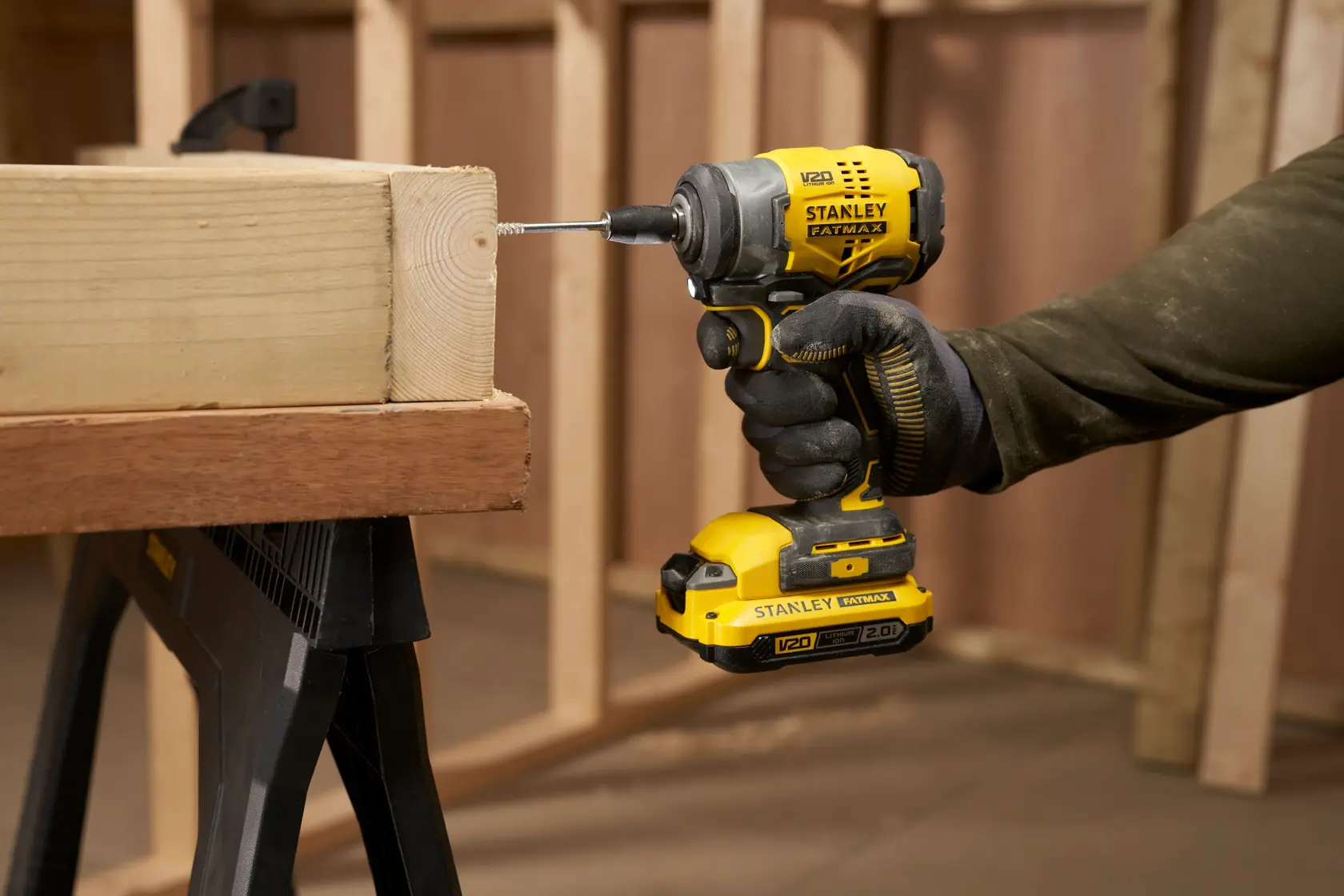 Foto dell’avvitatore a impulsi senza fili STANLEY SFMCF910B in uso per avvitare una vite nel legno in un cantiere.